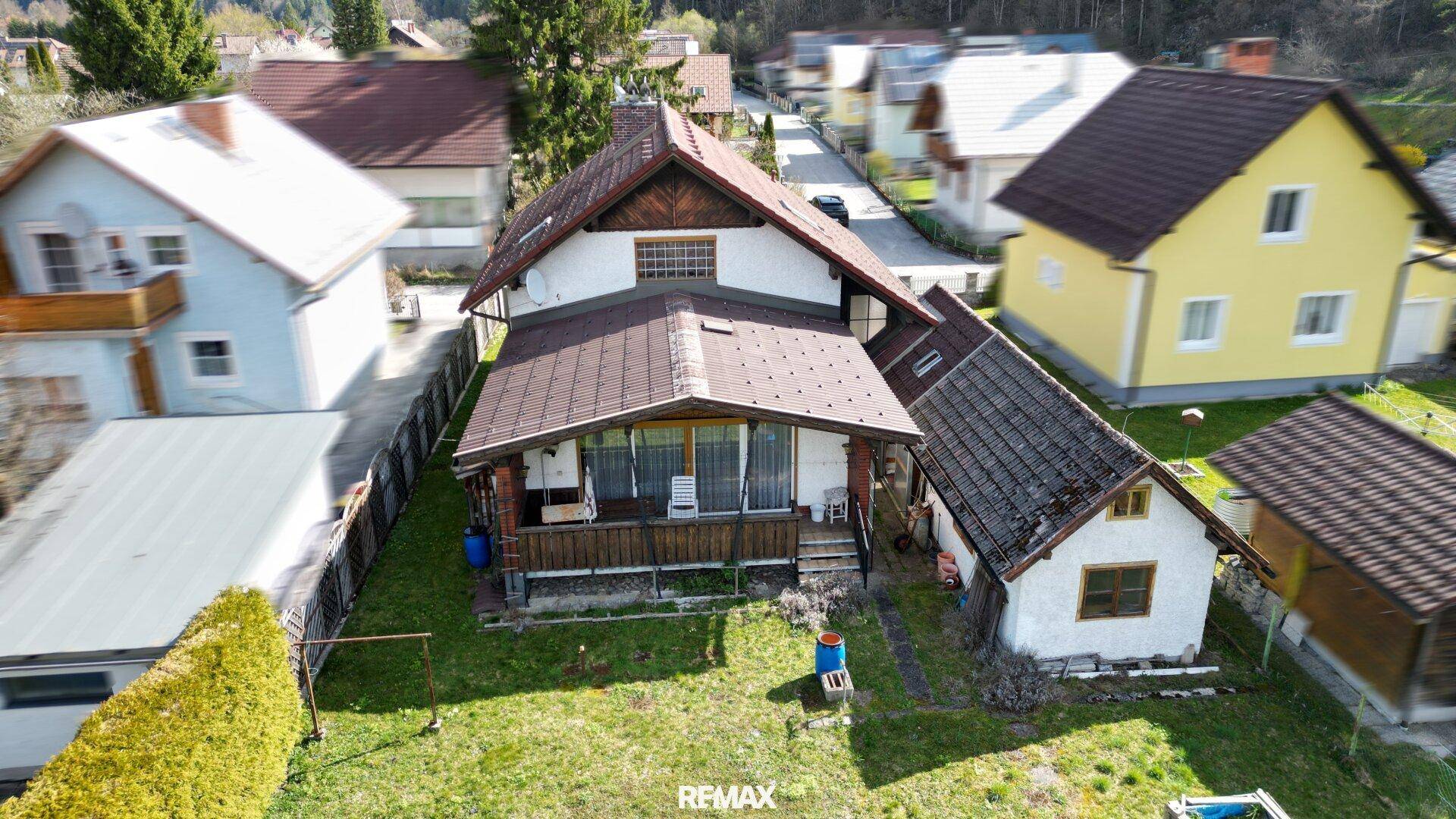 Rückansicht des Hauses mit großem Garten und überdachtem Balkon im ländlichen Stil.