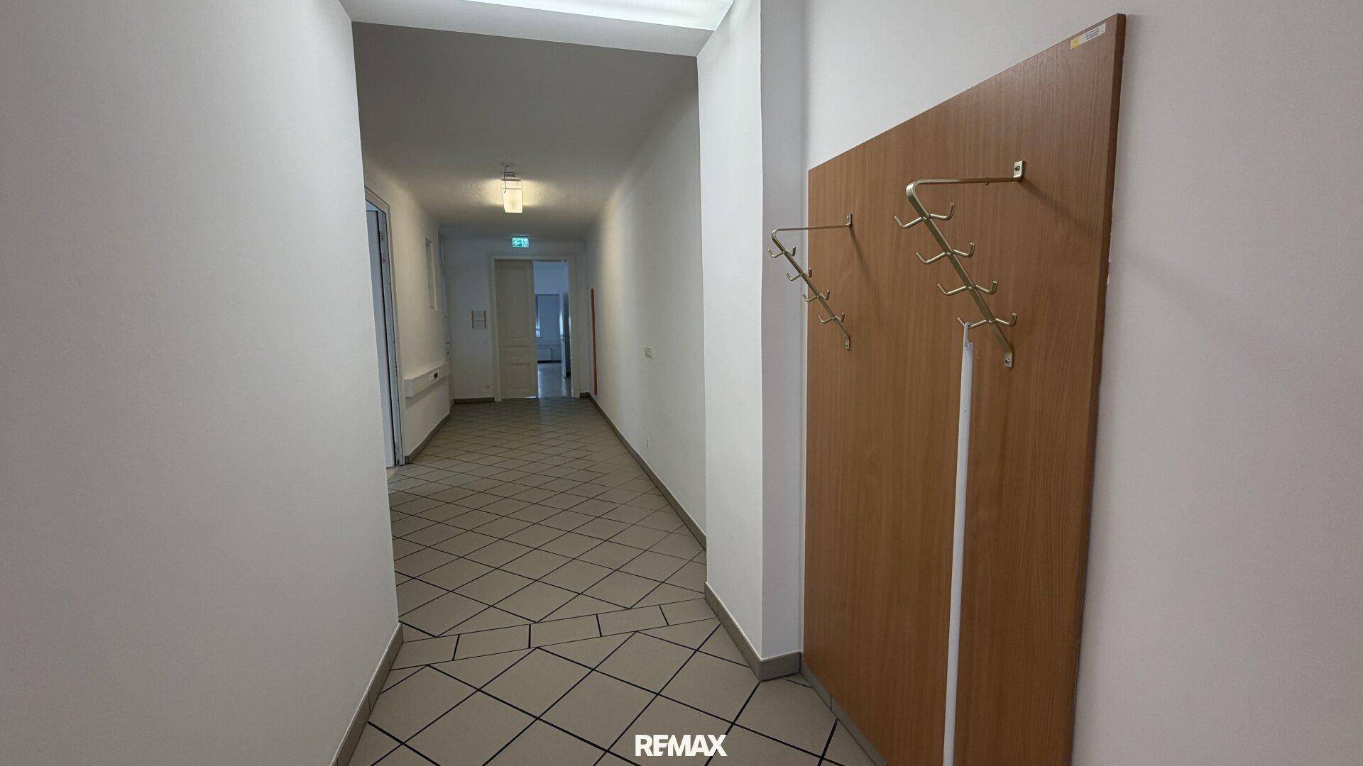 Flur mit gefliestem Boden und einer Garderobe an der Wand, die zu weiteren Räumen führt.