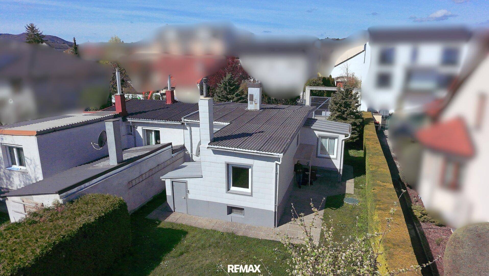 Luftaufnahme des Hauses aus einer anderen Perspektive, umgeben von Nachbargebäuden und Grünflächen.