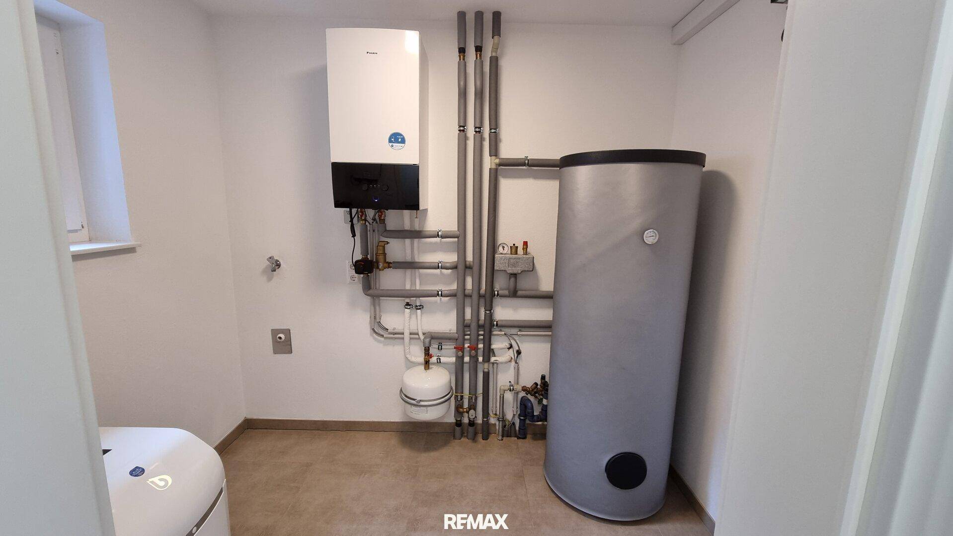 Technikraum mit moderner Heizungsanlage und Warmwasserspeicher, gut organisiert und funktional.