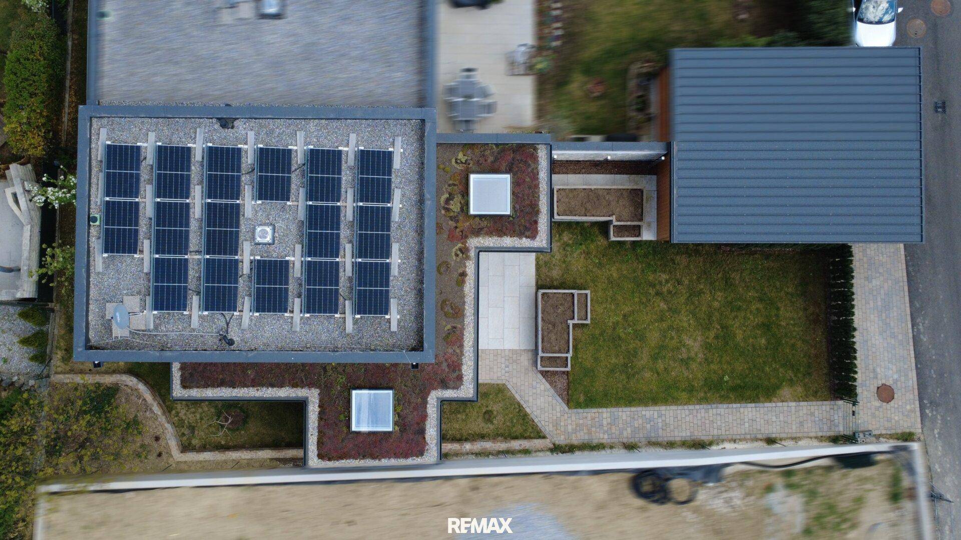 Vogelperspektive des Anwesens mit Solaranlage, Gründach und detaillierter Gartengestaltung.