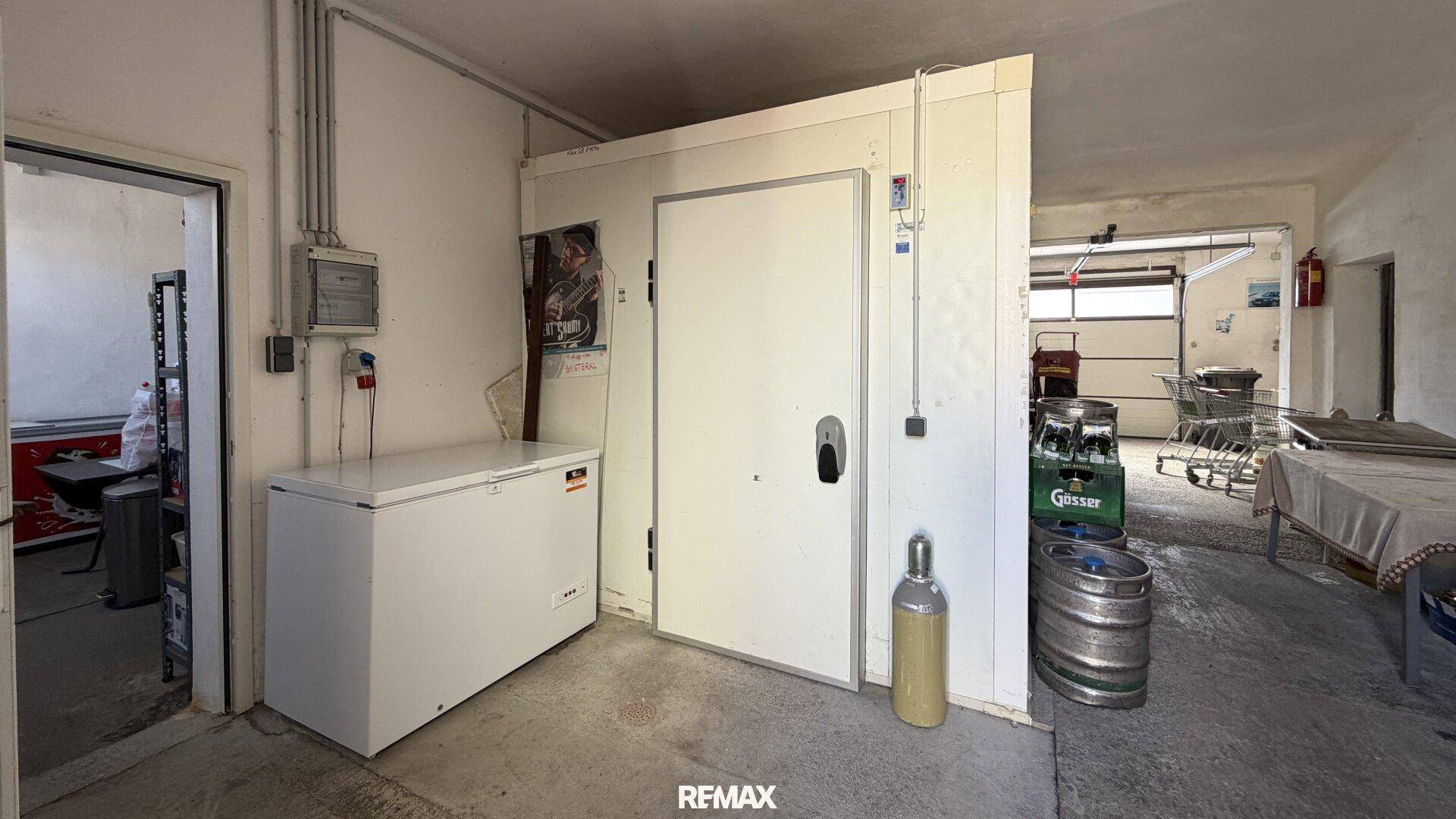Großer Lagerraum mit Gefriertruhe, Kühlraumtür und Bierfässern, ideal für gewerbliche Nutzung.