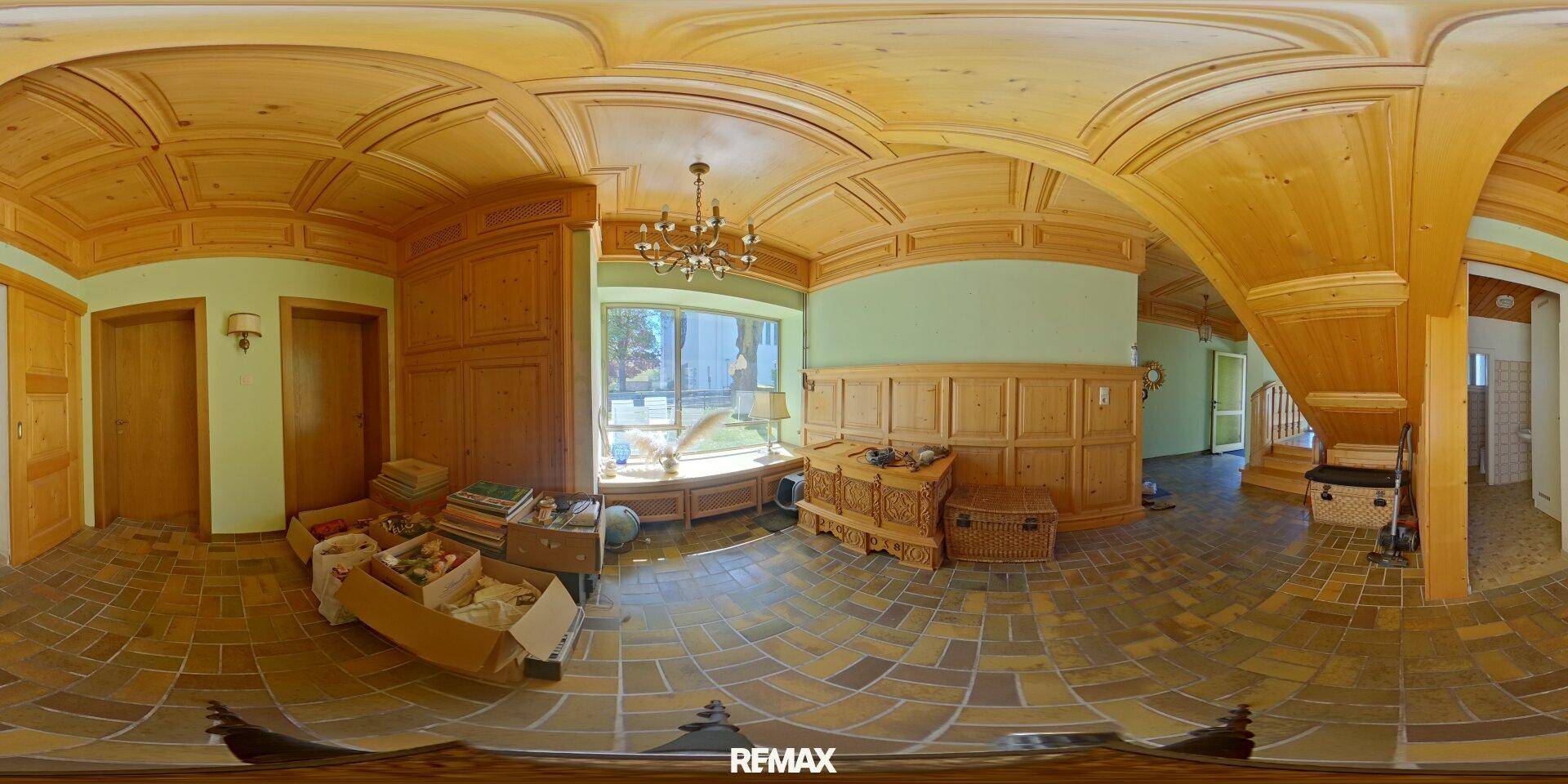 Panoramablick in einen traditionellen Bereich mit Holztäfelung, gemustertem Fliesenboden und einem Kronleuchter.