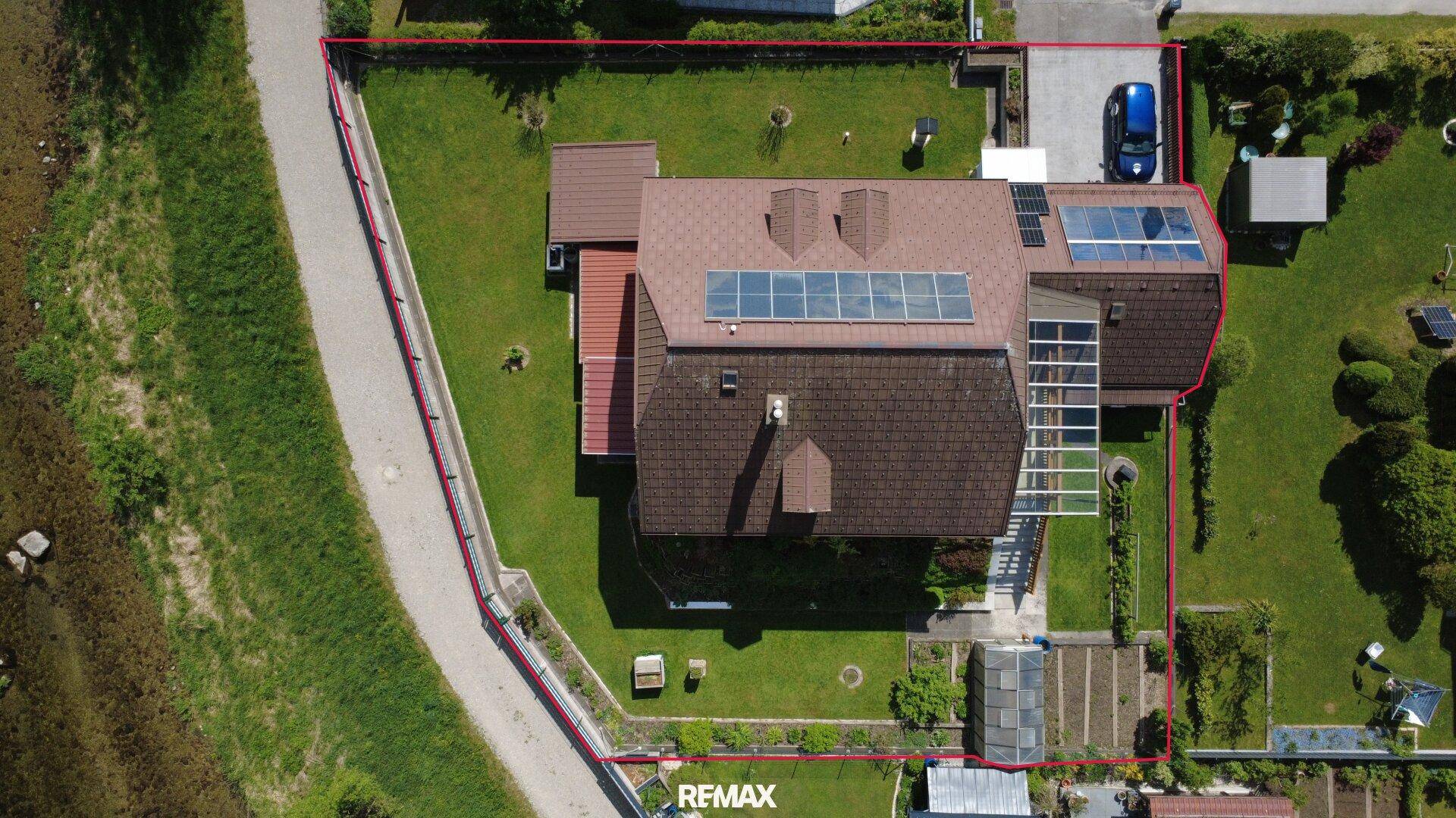 Vogelperspektive des Anwesens mit Solaranlagen auf dem Dach und angrenzendem Gartenbereich.