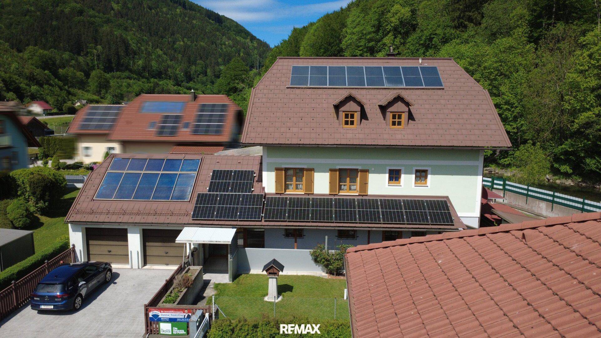 Vorderansicht des Hauses mit Doppelgarage, Solaranlagen auf dem Dach und gepflegtem Vorgarten.