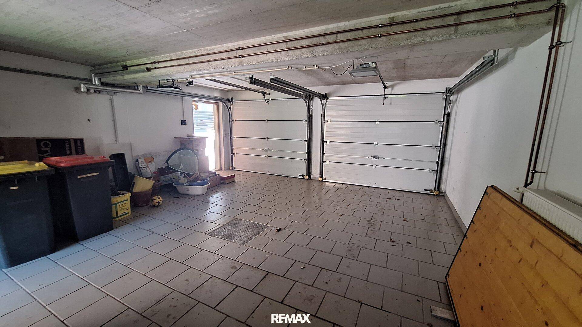 Doppelgarage mit gefliestem Boden und zwei Sektionaltoren.