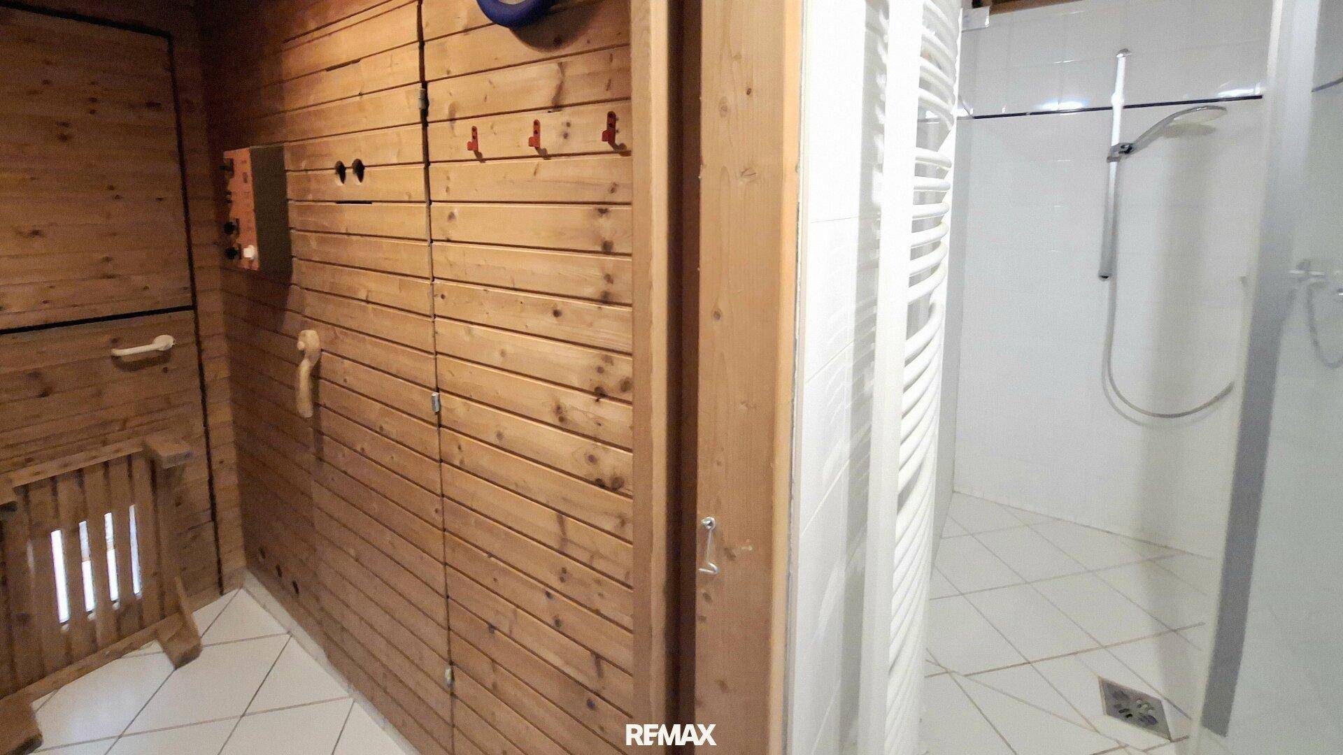 Holzvertäfelte Sauna mit Sitzbänken und Heizofen, bereit für entspannende Momente.