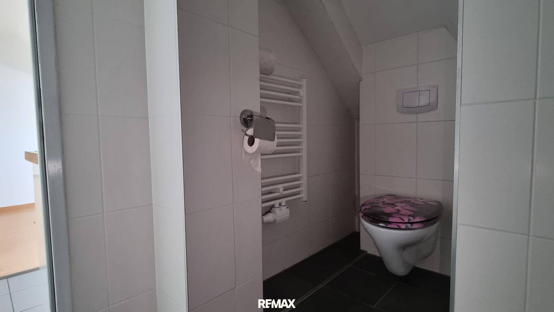 Separates WC mit wandhängender Toilette und beheiztem Handtuchhalter.
