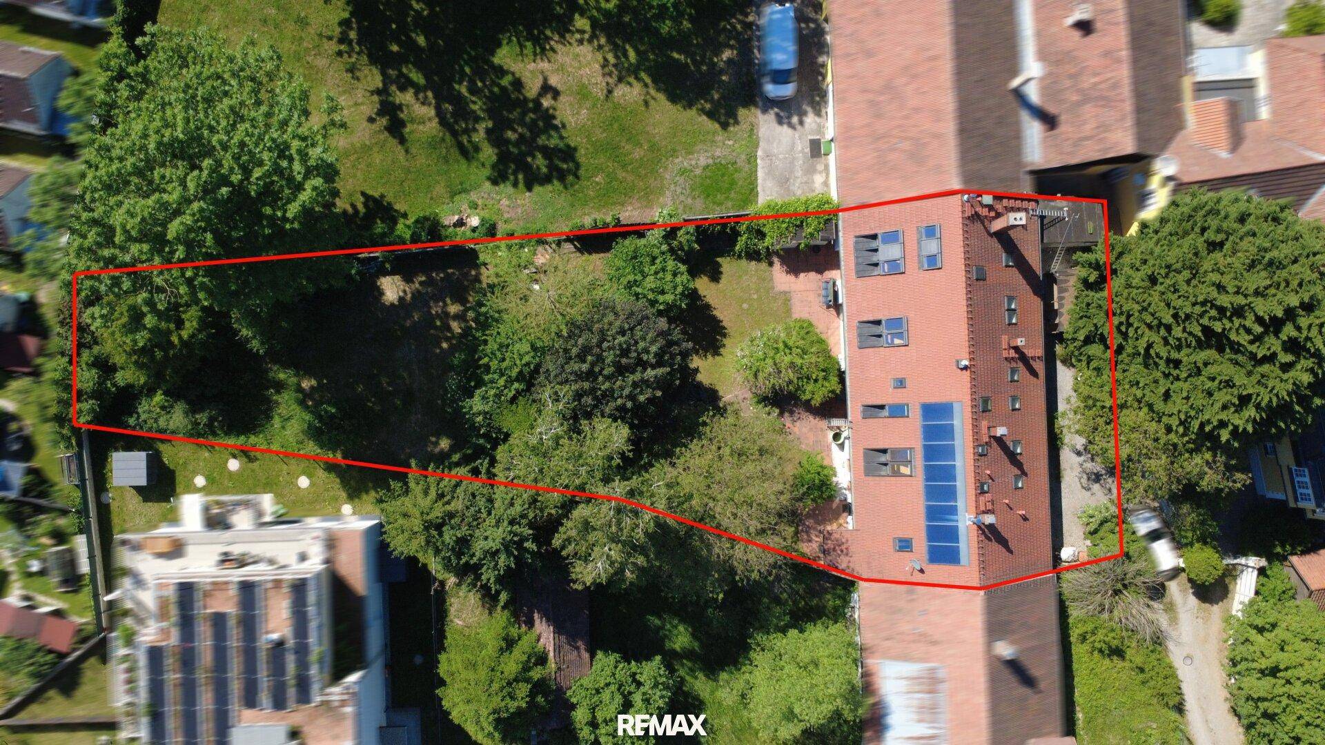 Luftaufnahme des Grundstücks mit großem Gartenbereich und Photovoltaikanlage auf dem Dach.