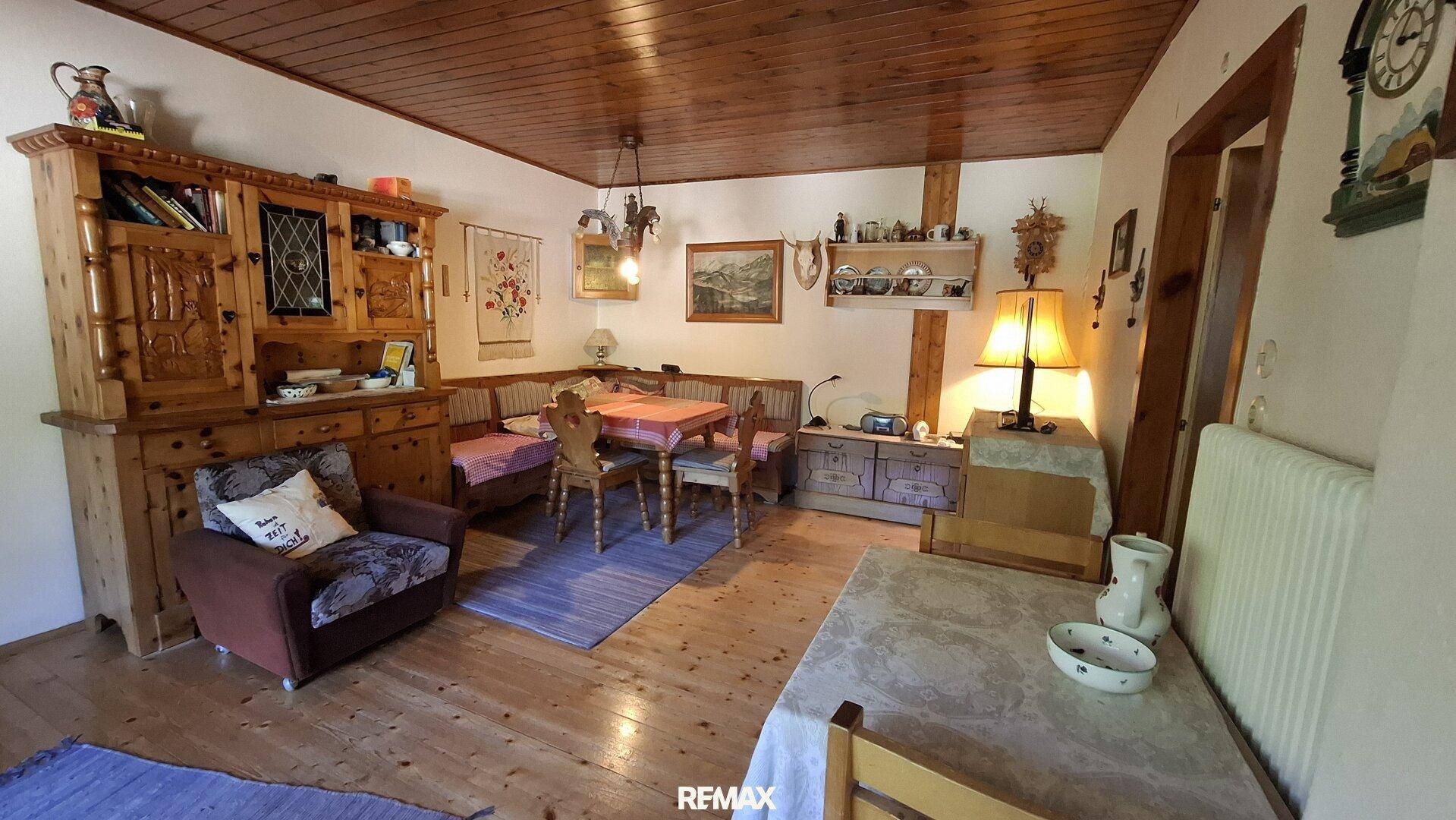 Gemütlicher Wohn-Essbereich im Landhausstil mit Holzboden und Holzdecke.