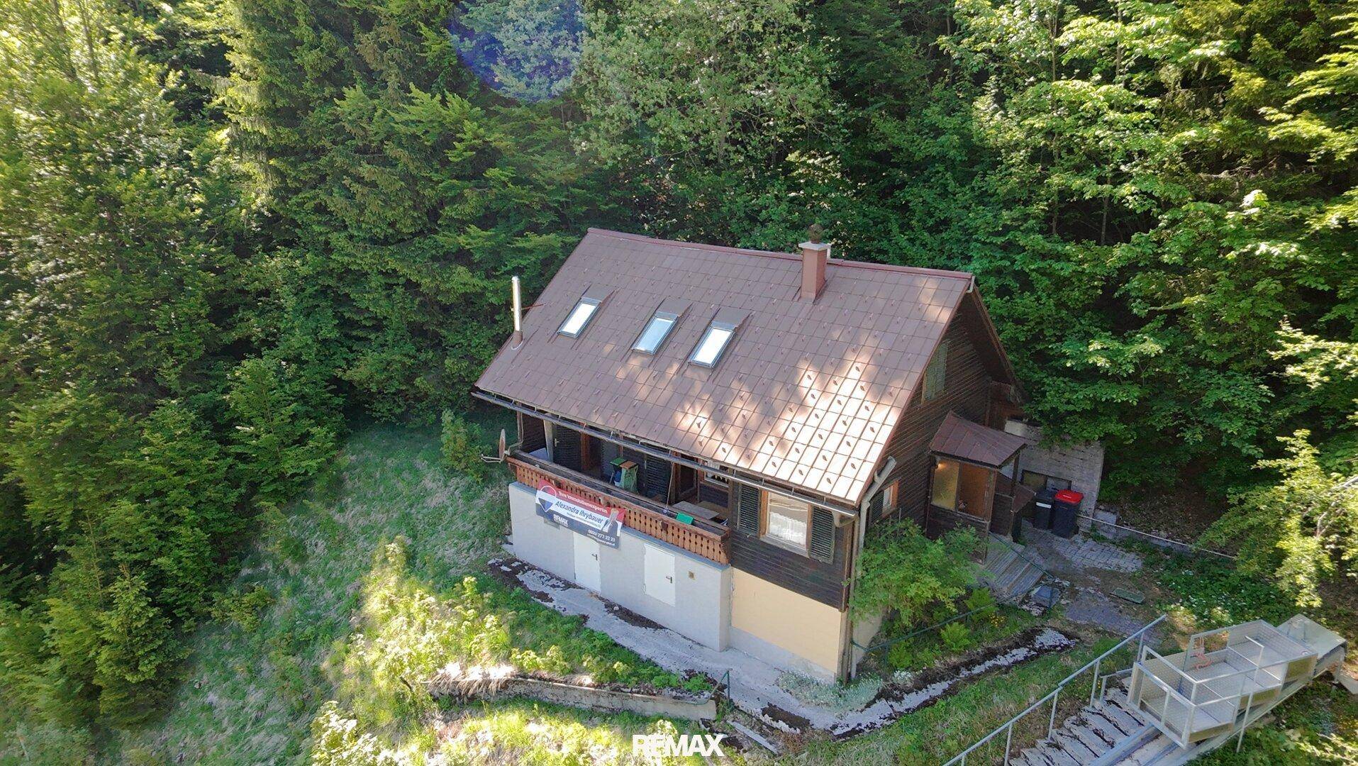 Luftaufnahme des Hauses in idyllischer Waldlage mit privater Seilbahn.