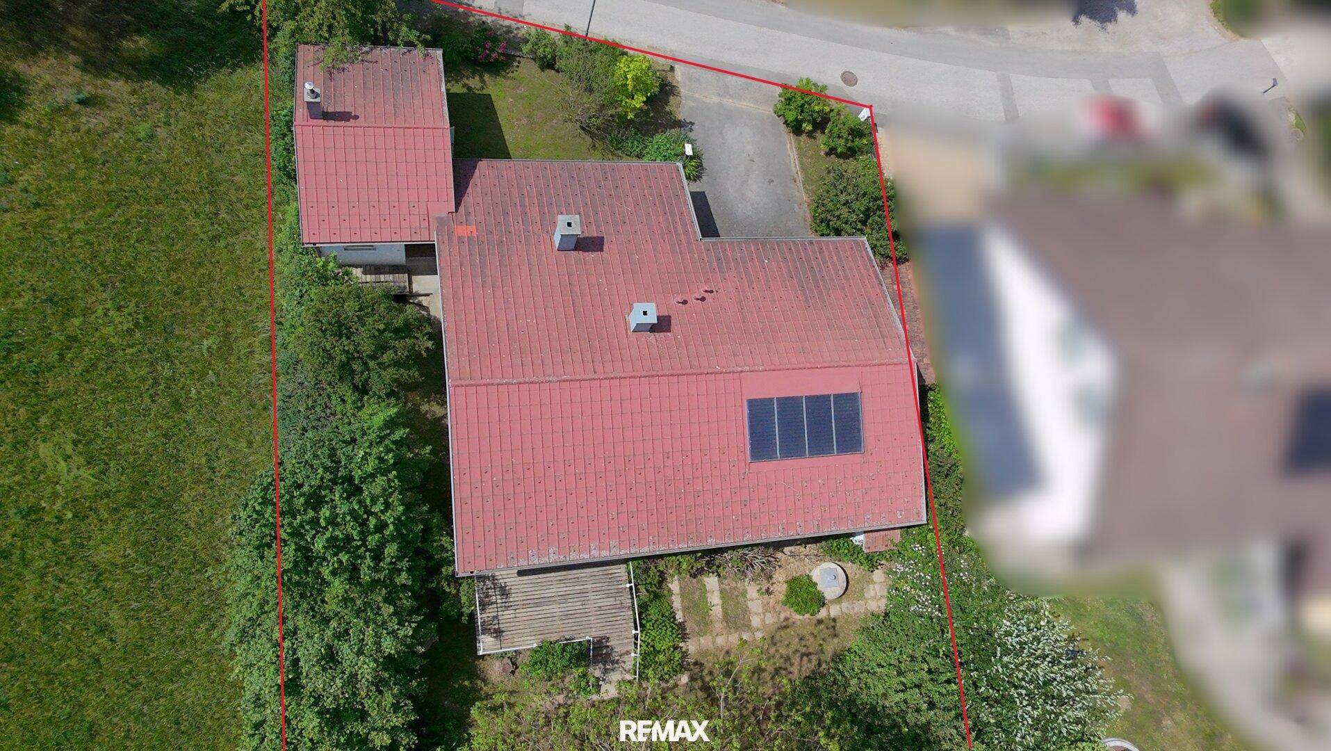 Übersicht des Grundstücks mit Haus, Nebengebäude und roter Grenzmarkierung.
