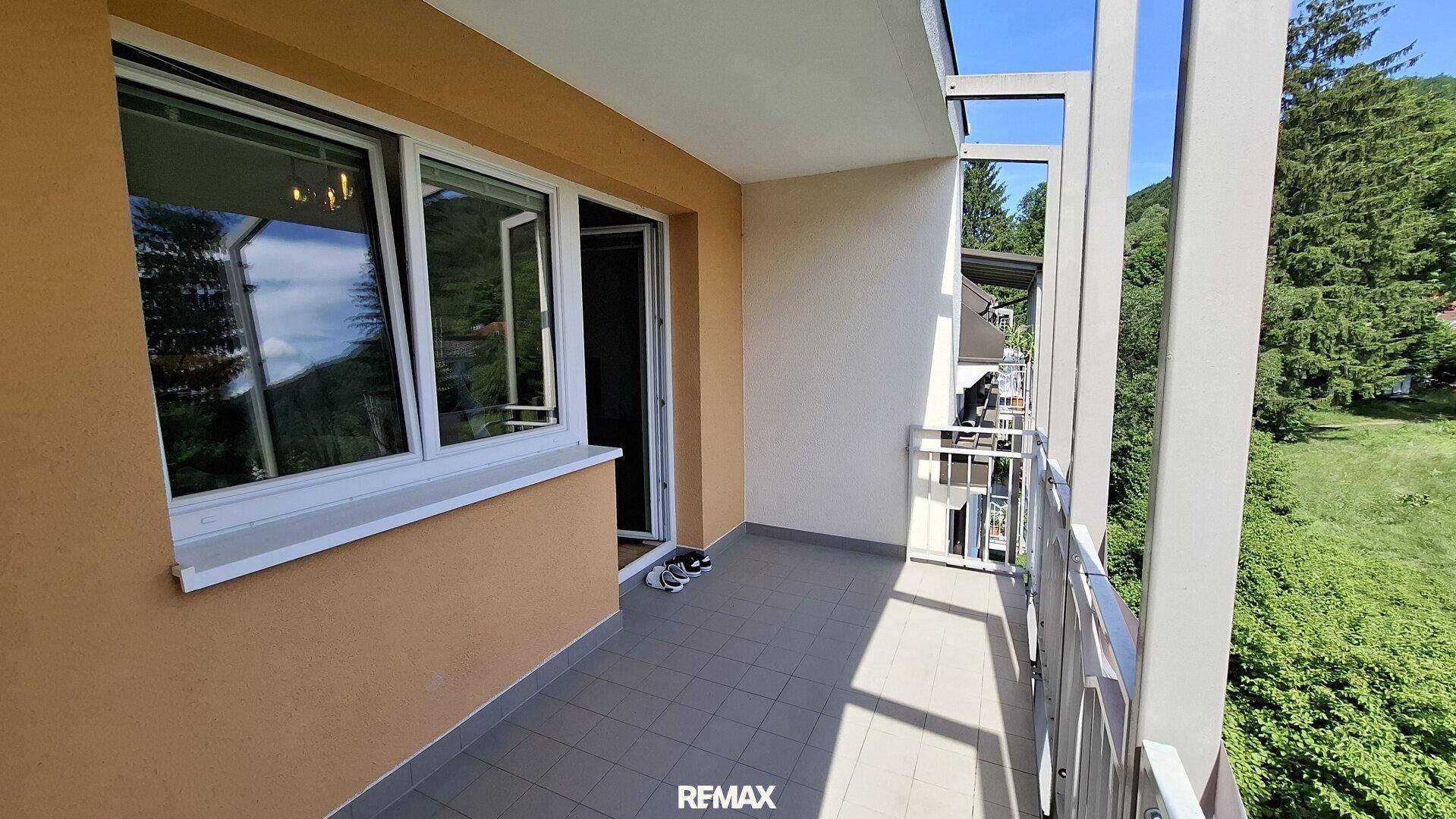 Geräumiger Balkon mit Blick auf grüne Hügel und die umliegende Natur an einem sonnigen Tag.
