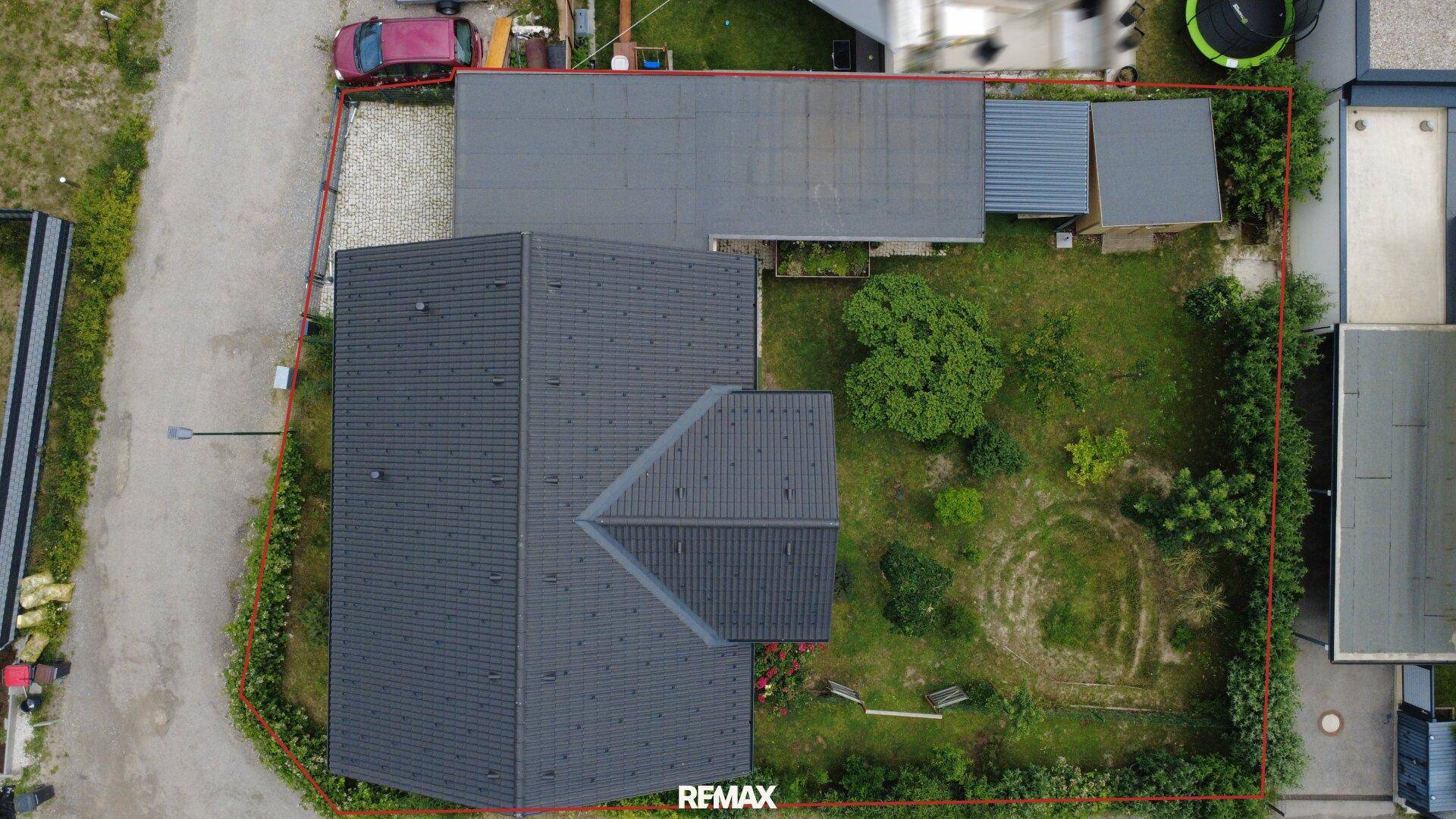 Draufsicht auf das Haus mit Satteldach und den weitläufigen Gartenbereich mit Rasenfläche.