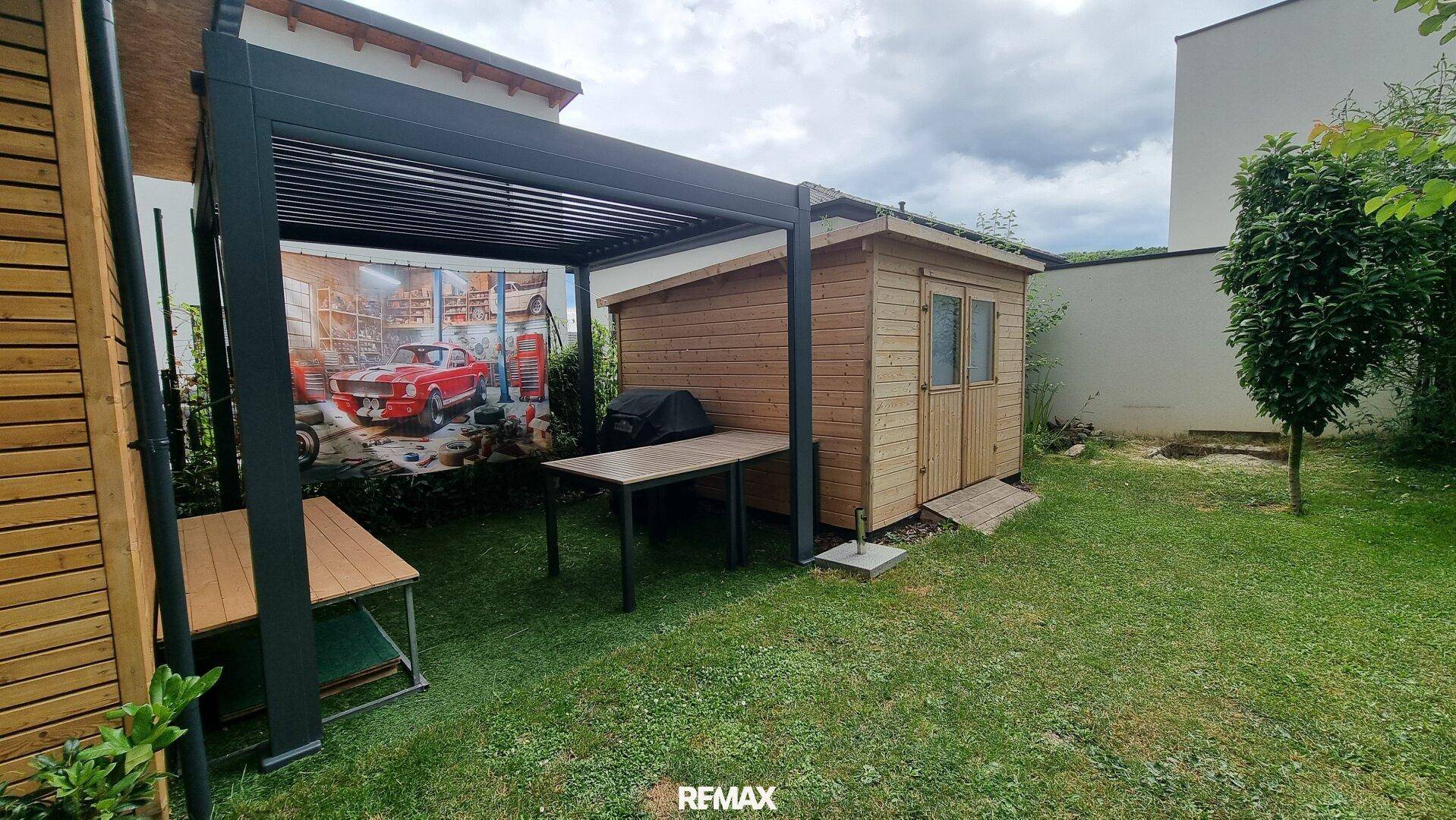 Gepflegter Gartenbereich mit Pergola, Gartenhaus und Grillplatz für entspannte Stunden im Freien.