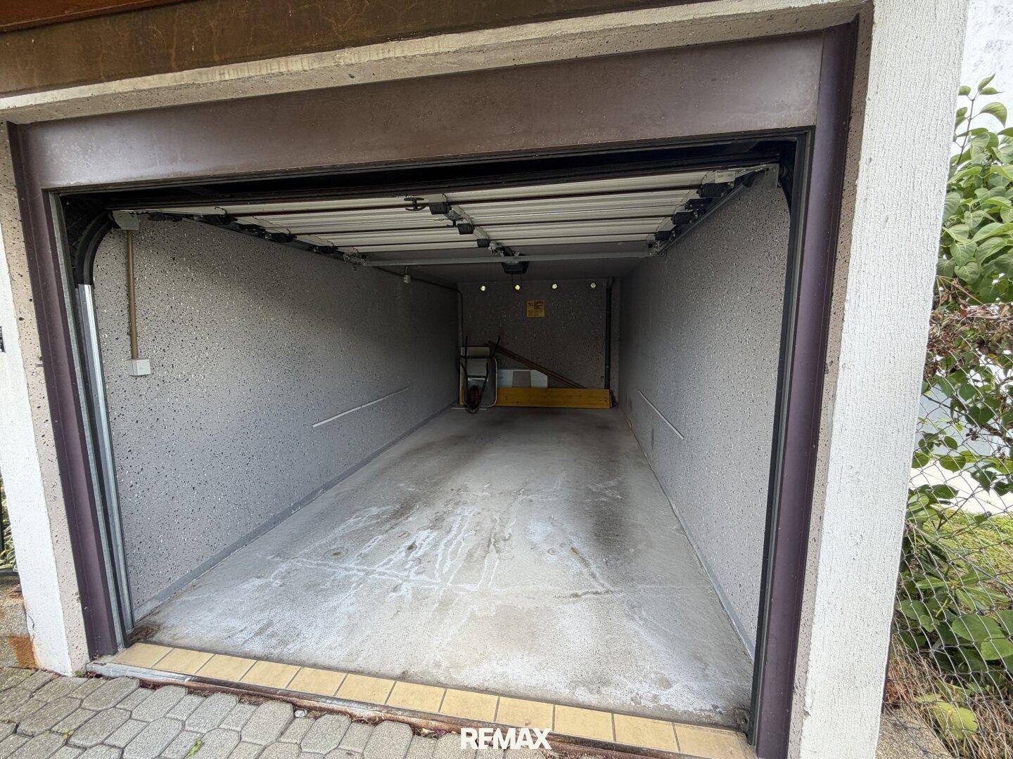 Leere Garage mit offenem Tor, bereit für die Unterbringung eines Fahrzeugs oder als Stauraum.