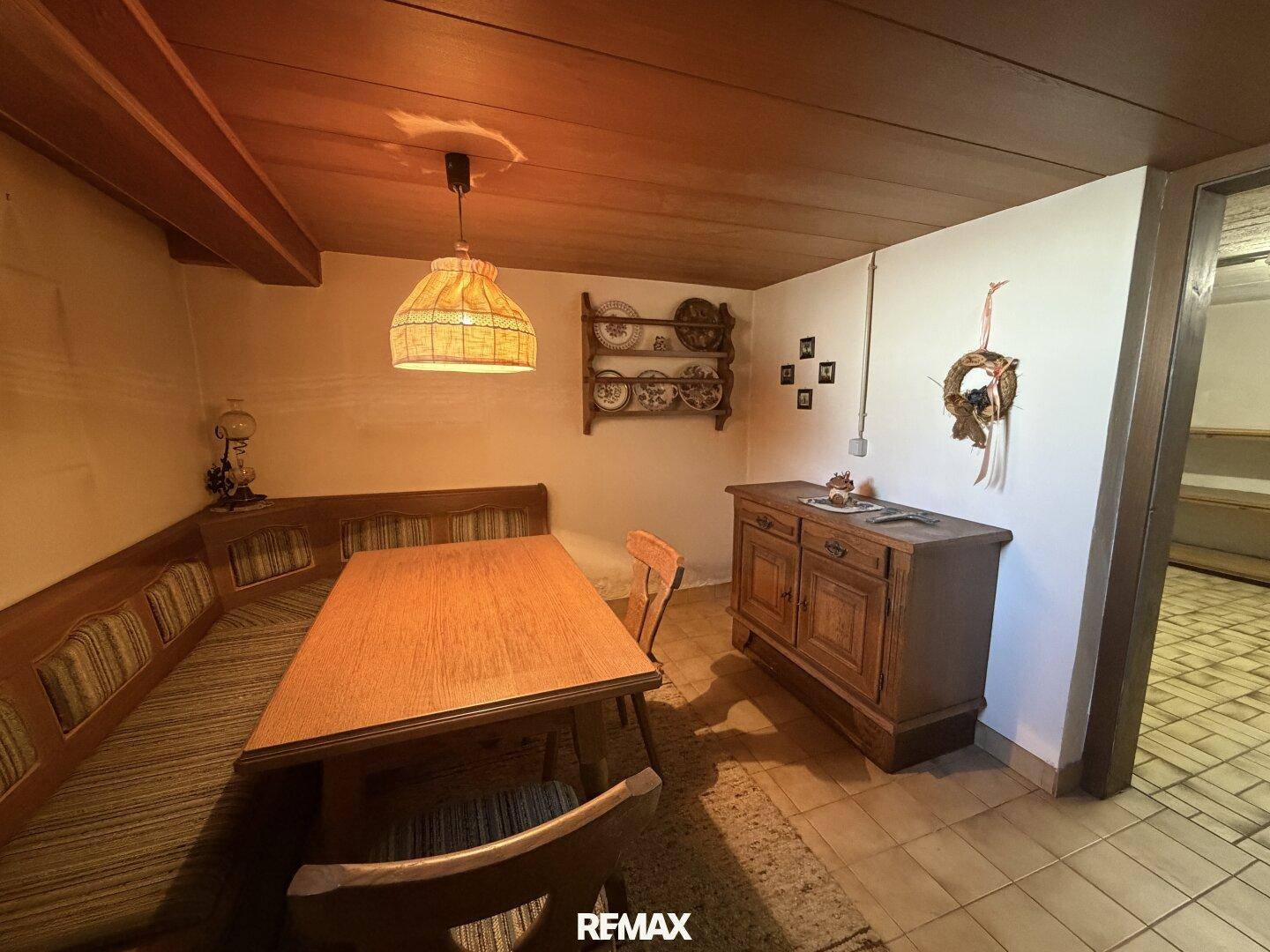 Gemütlicher Kellerraum mit traditioneller Sitzecke und Holztisch.