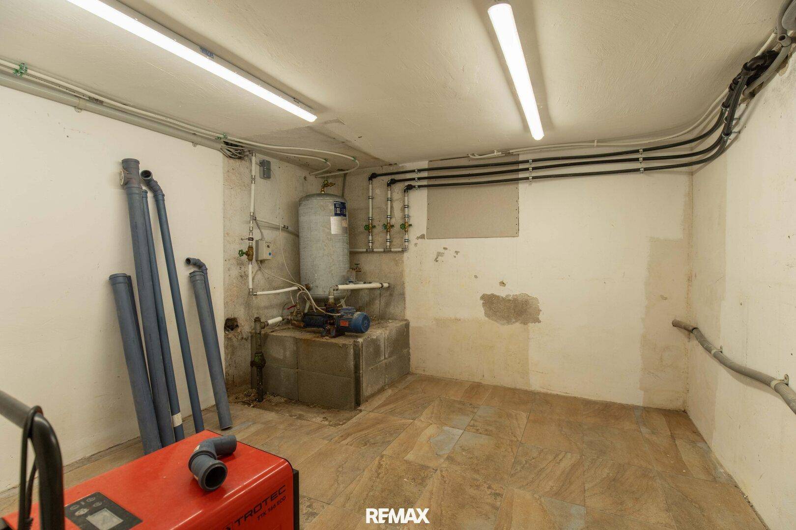 Technikraum im Keller mit Wasserinstallationen und Pumpen.