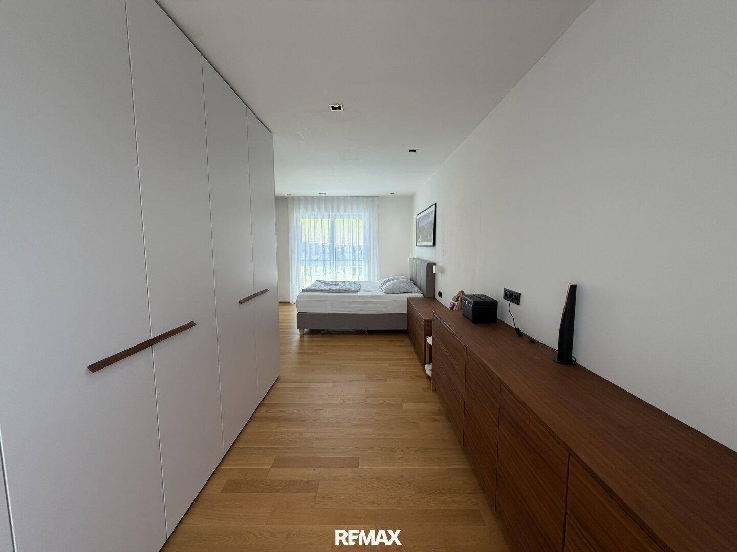 Schlafzimmer mit Holzboden, integrierten Kleiderschränken und viel Stauraum.