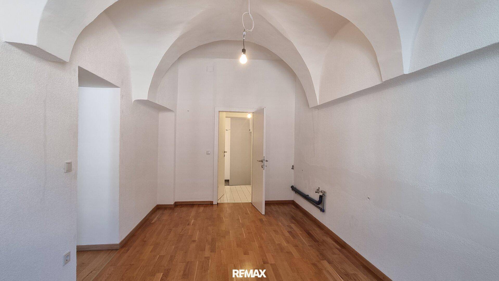 Heller Raum mit beeindruckender Gewölbedecke und Holzboden, vielseitig nutzbar.