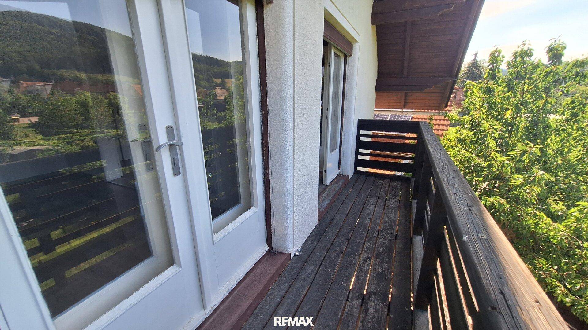 Balkon mit Holzgeländer und Holzboden, bietet einen schönen Blick ins Grüne.