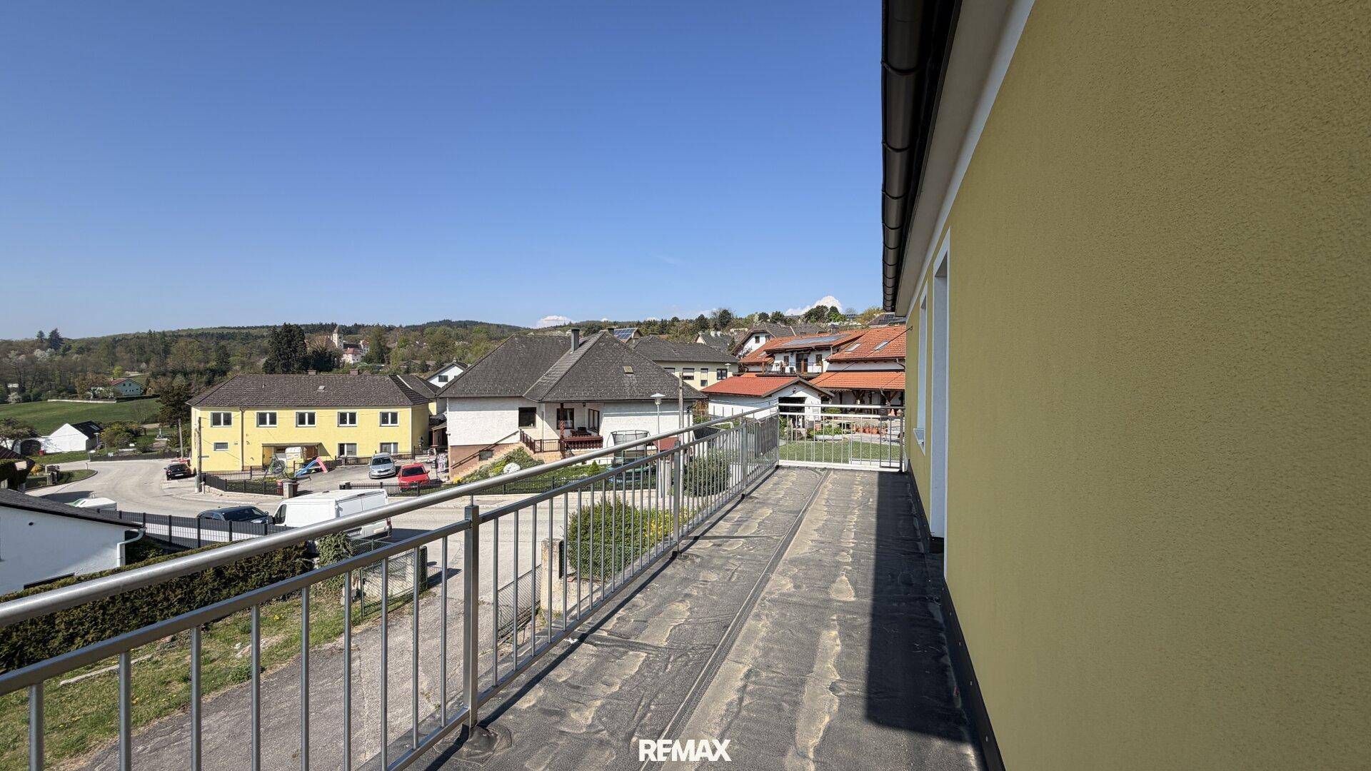 Geräumiger Balkon mit Panoramablick auf die umliegende Wohngegend und Natur.
