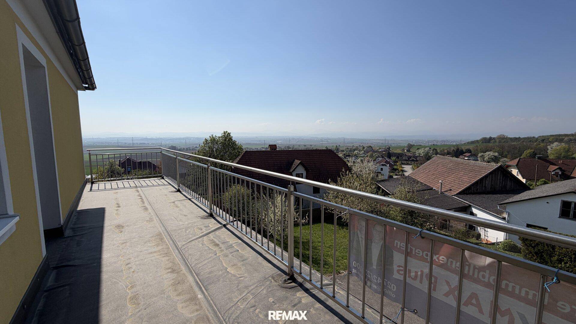 Langer Balkon mit Metallgeländer und weitem Blick über die Landschaft.