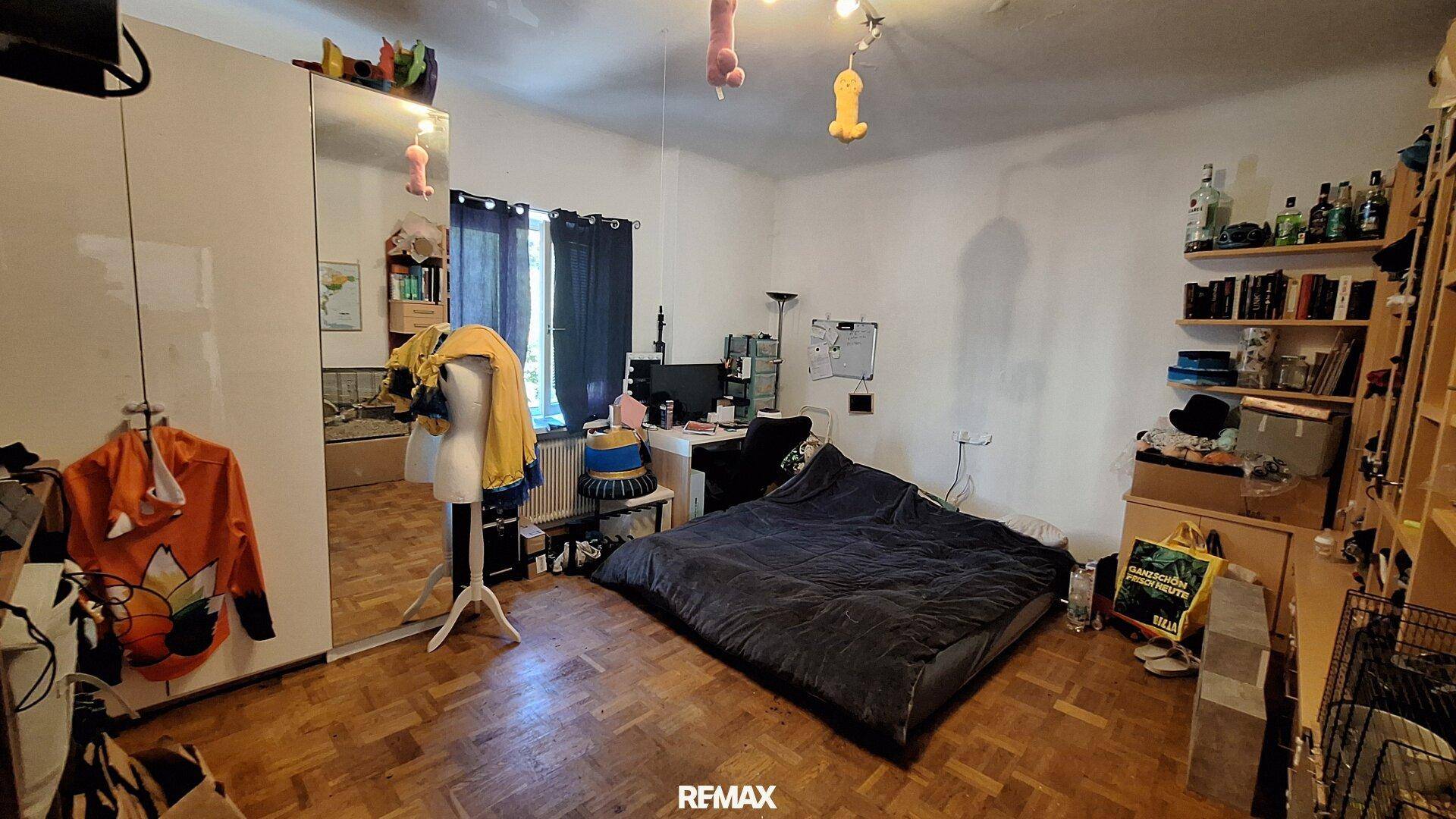 Geräumiges Schlafzimmer mit Holzboden, großem Spiegelkleiderschrank und Schreibtisch.