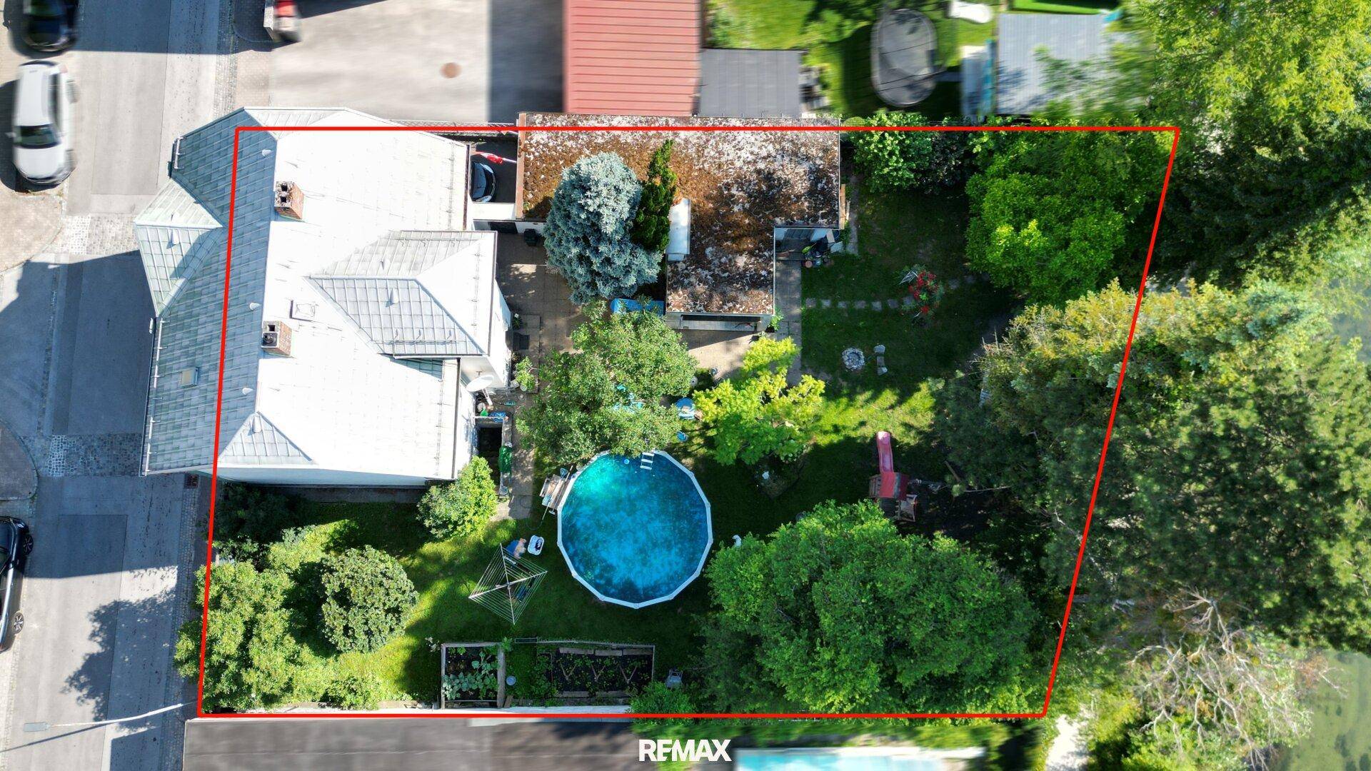 Vogelperspektive des Grundstücks mit Haus, Garten, Pool und umrandeter Fläche.