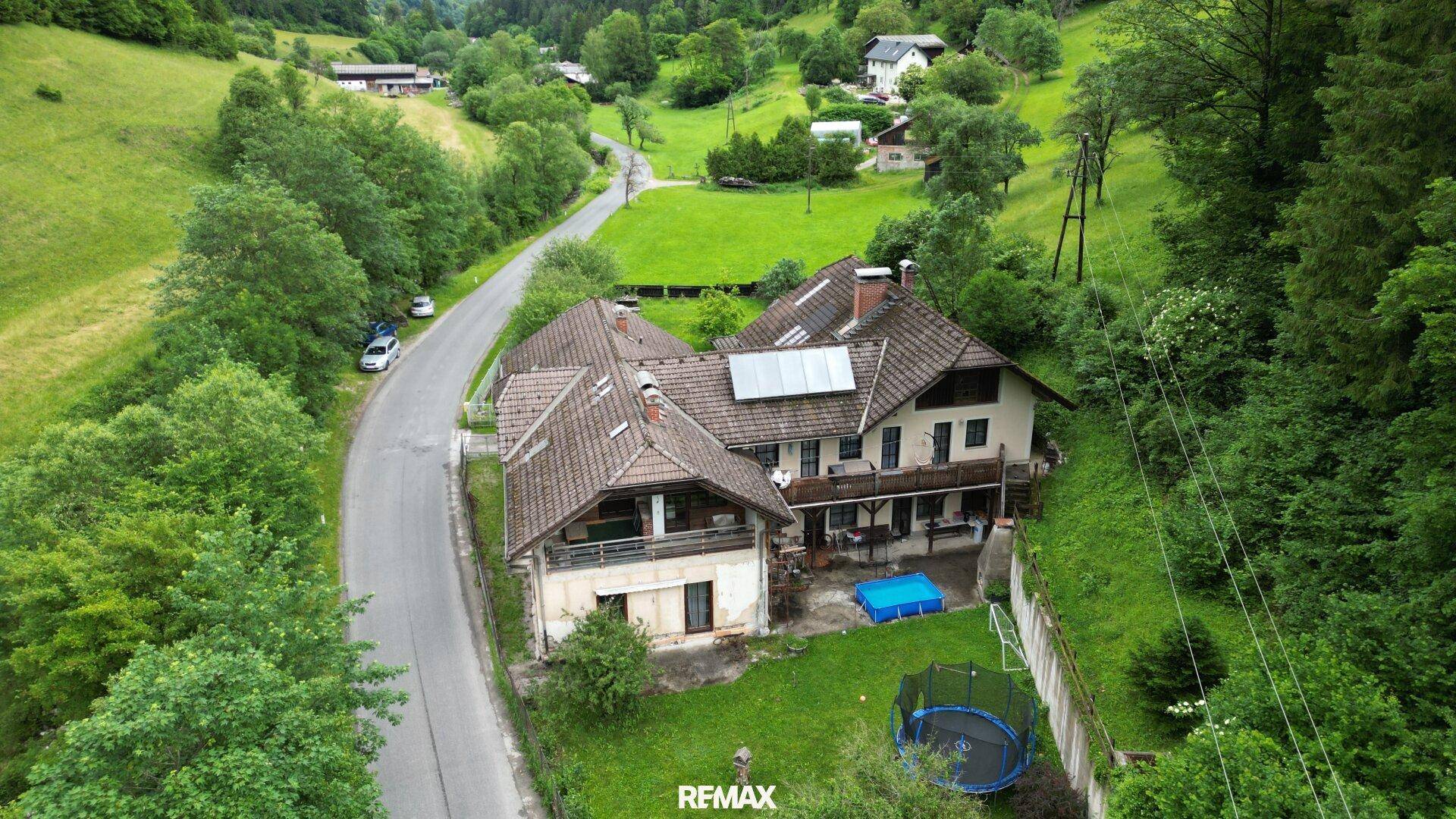 Weitläufige Luftaufnahme des Anwesens in ländlicher Umgebung mit Trampolin und Pool.