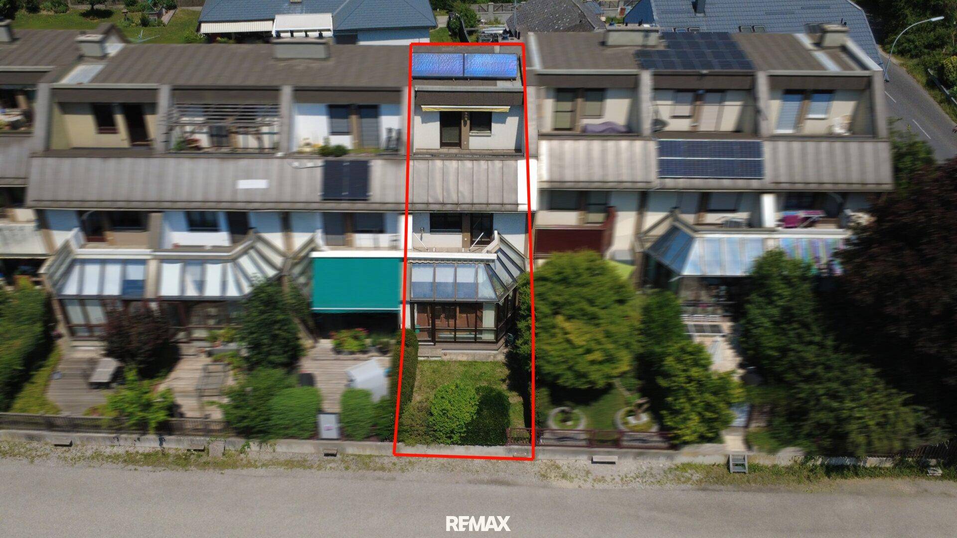 Luftaufnahme einer Reihenhaussiedlung mit Solaranlagen auf den Dächern, das Objekt ist rot umrandet.