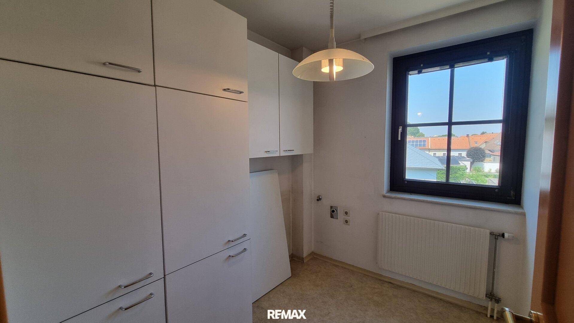 Kleiner Raum mit weißen Einbauschränken und Fenster, ideal als Abstell- oder Hauswirtschaftsraum.