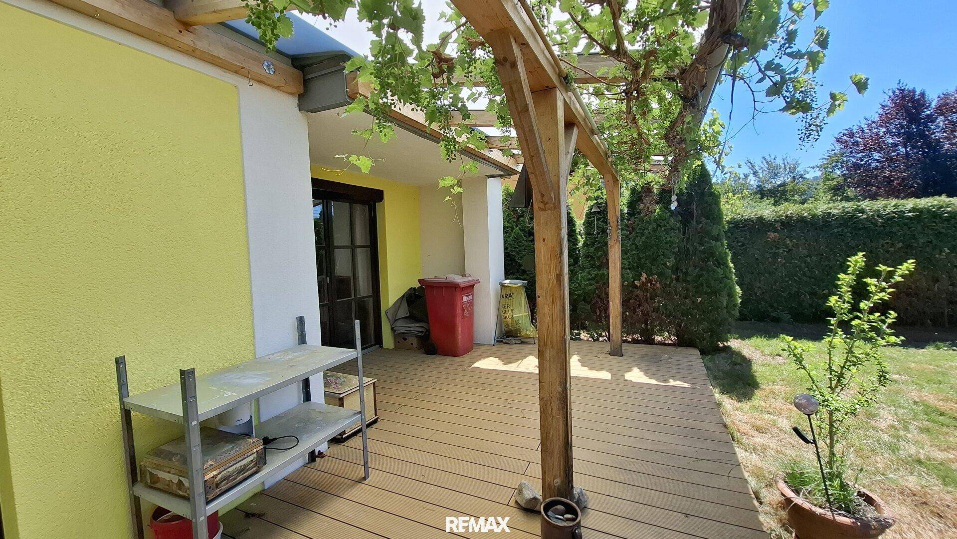 Holzterrasse mit Pergola und Weinreben, ideal für entspannte Stunden im Freien.
