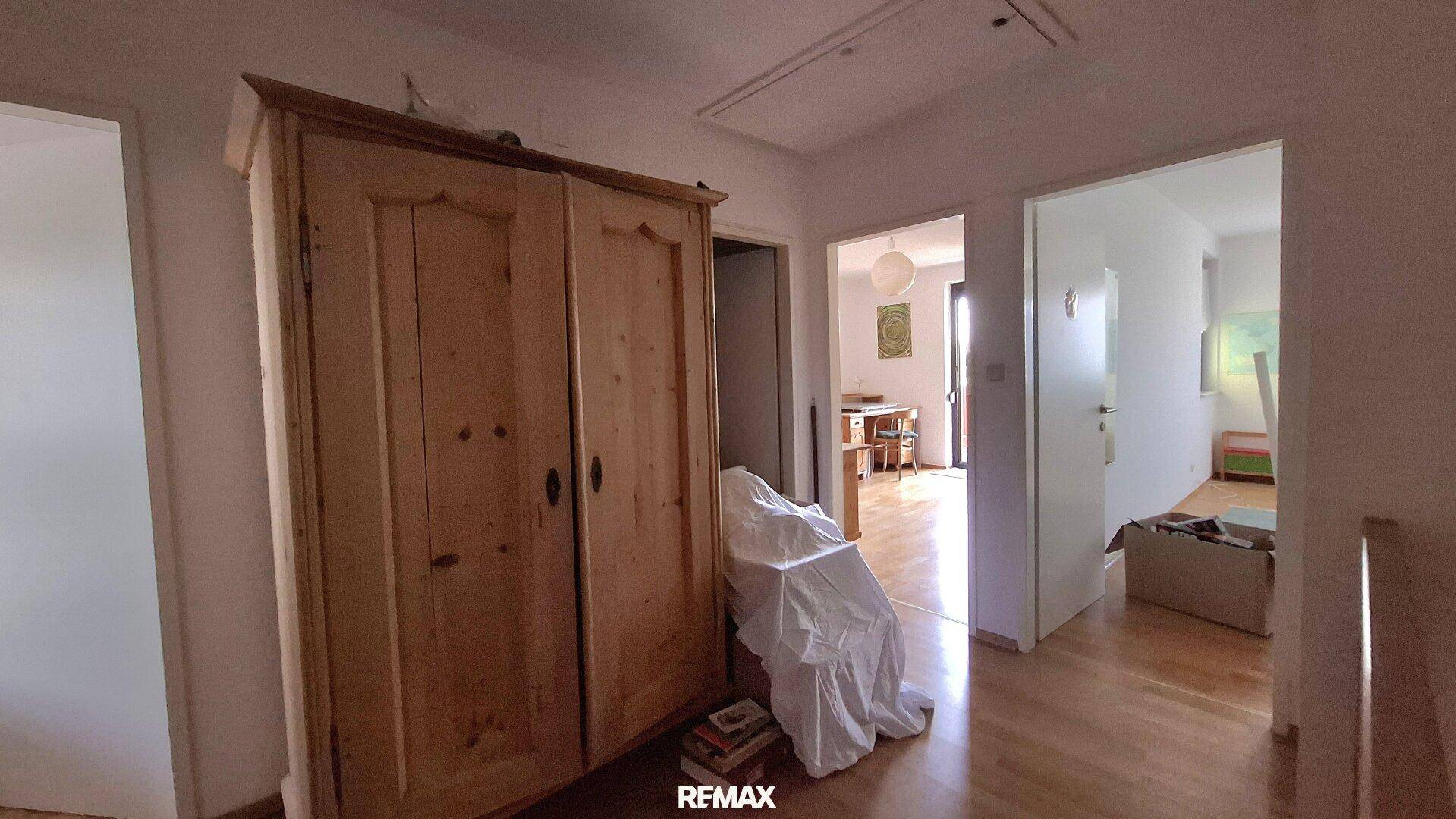 Oberer Flur mit großem Holzschrank und Zugang zu weiteren Zimmern.
