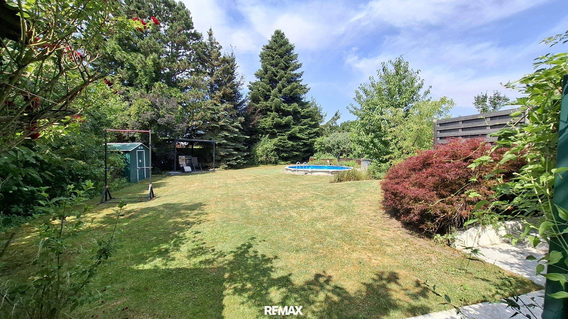 Großer, gepflegter Garten mit Rasenfläche, Pool und Gartenhaus.