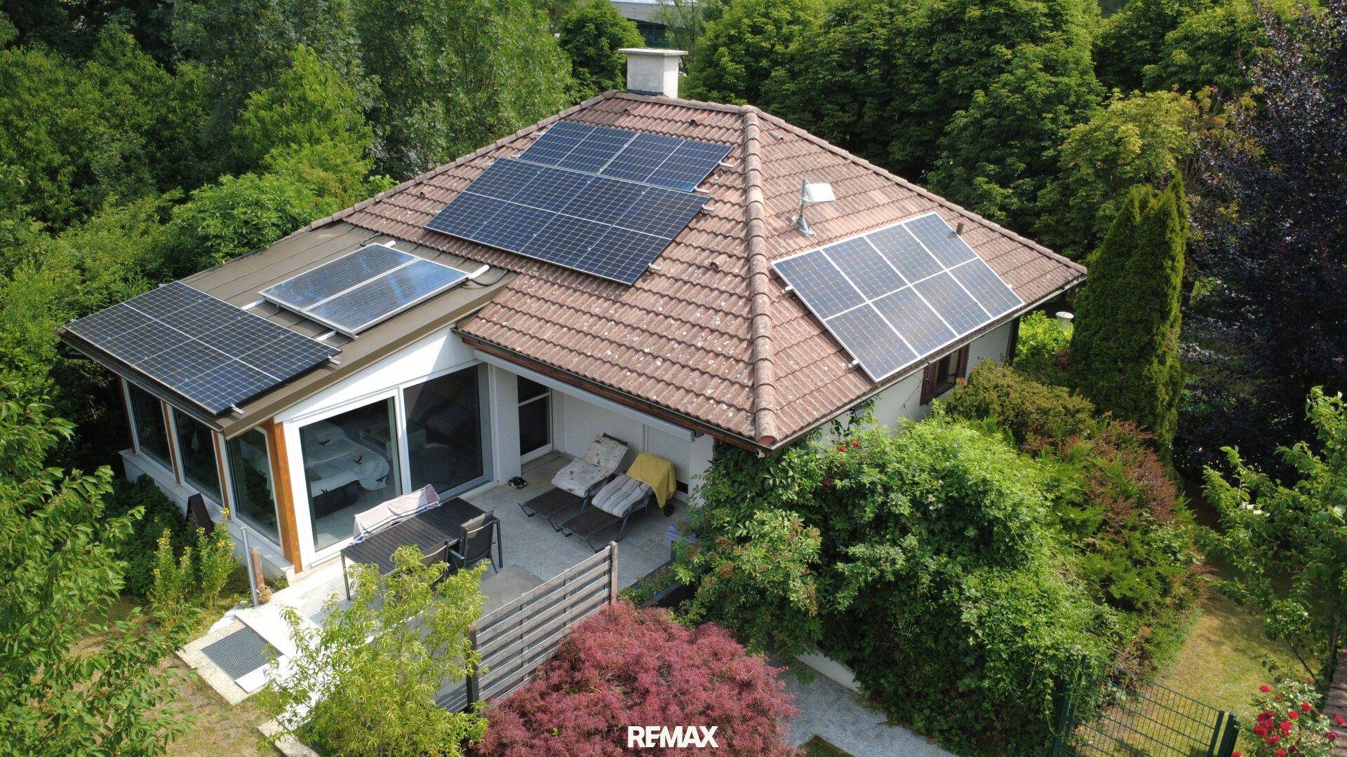 Luftaufnahme des Hauses mit Photovoltaikanlage auf dem Dach und umliegendem Garten.
