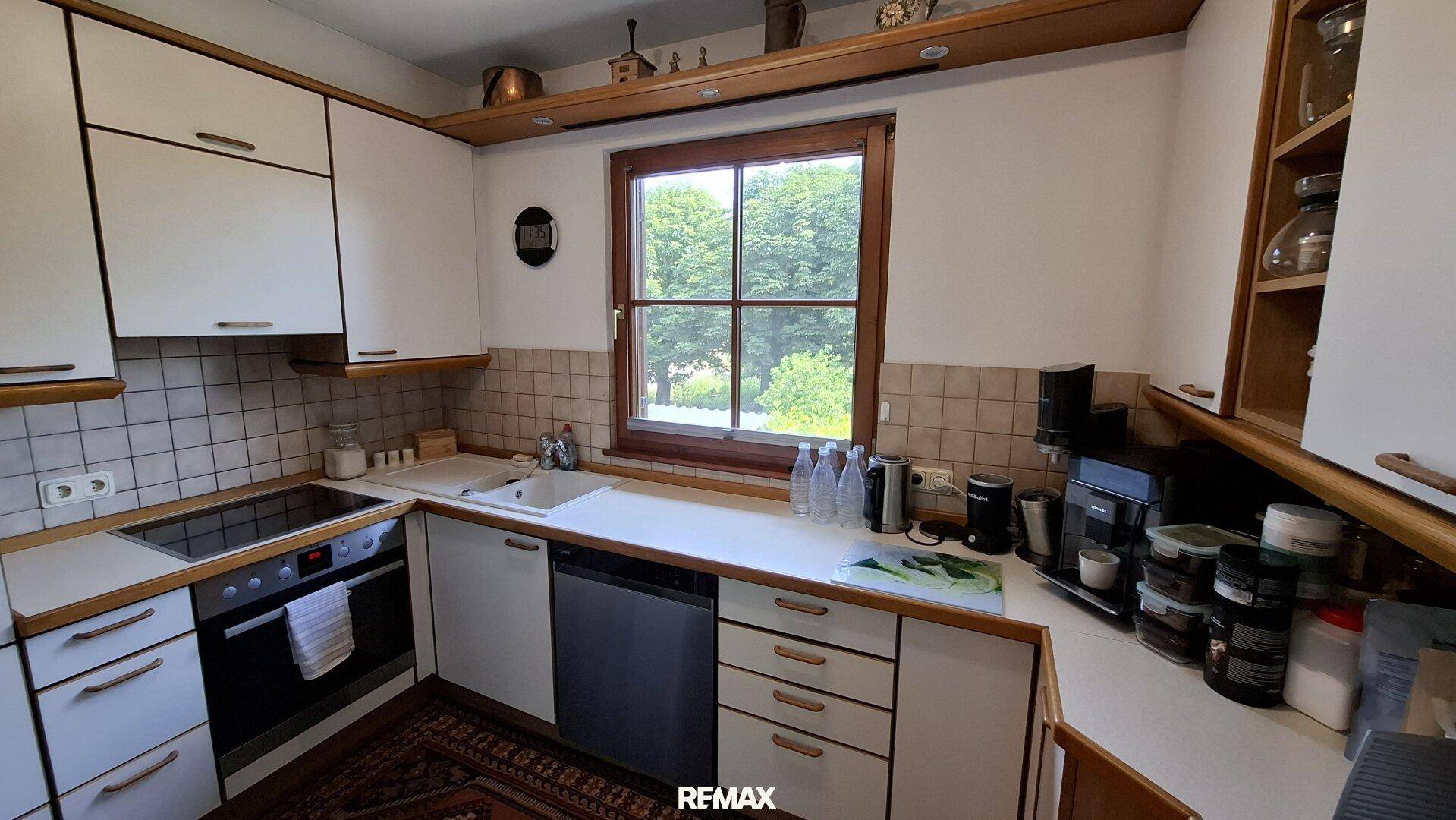 Funktionale Küche mit Einbaugeräten, Fenster und Blick ins Grüne.