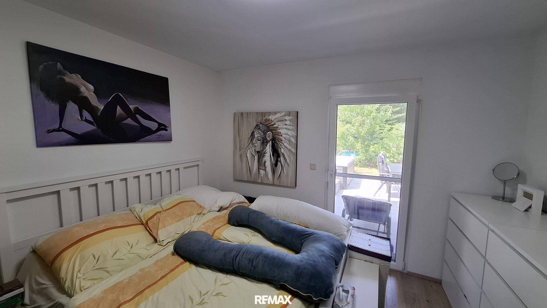 Schlafzimmer mit Zugang zur Terrasse und Blick ins Grüne.