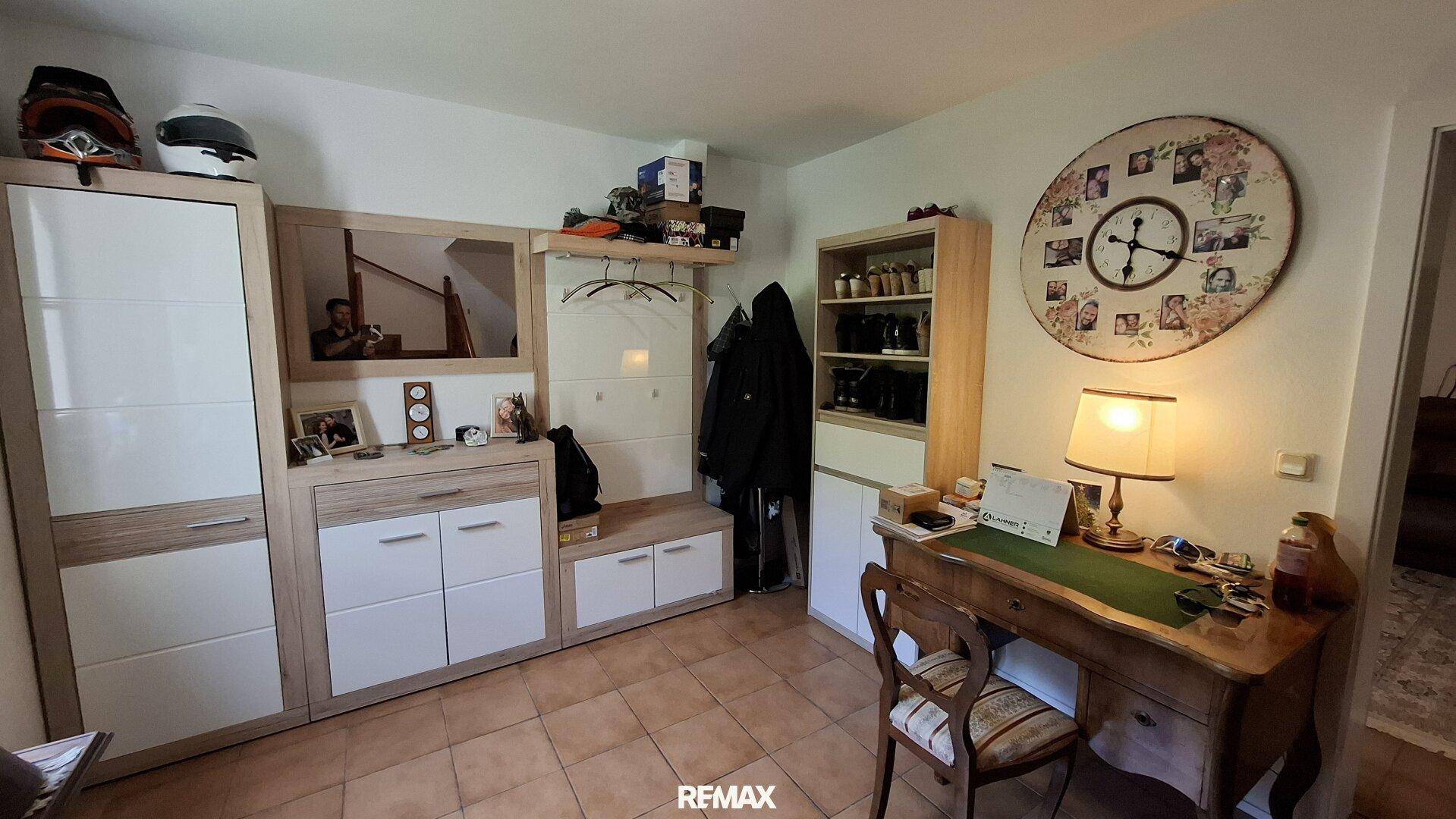Eingangsbereich mit Garderobe, Schuhschrank und kleinem Schreibtisch.