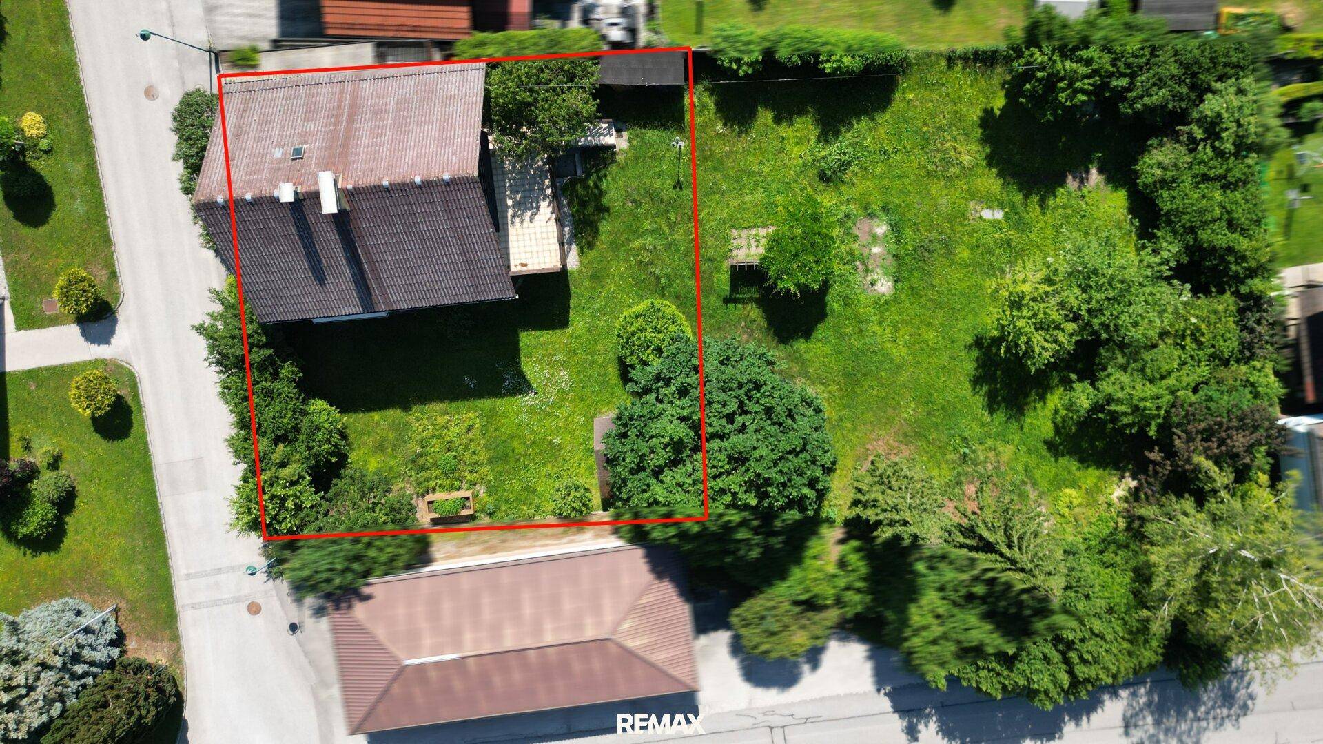 Draufsicht des Grundstücks mit Haus und großem Garten, umrandet von einer roten Linie zur besseren Orientierung.