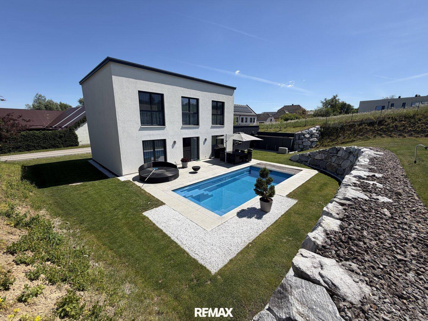 Modernes Einfamilienhaus mit Pool, gepflegtem Garten und sonniger Ausrichtung.