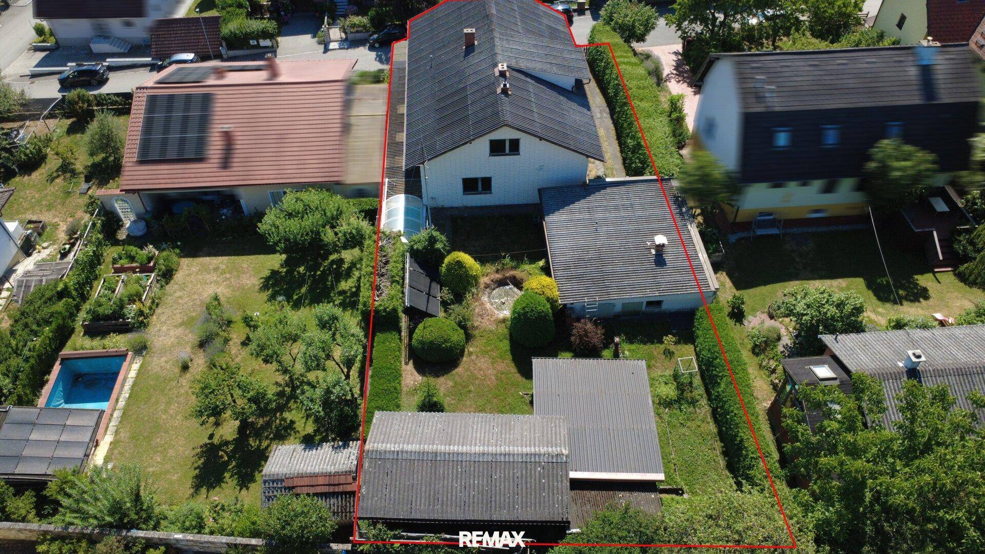 Vogelperspektive des Grundstücks mit Garten, Nebengebäuden und einem kleinen Poolbereich.