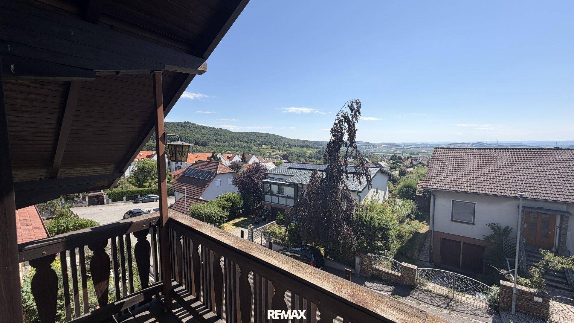 Panoramablick vom Balkon über die umliegende Wohnsiedlung und die grüne Hügellandschaft.