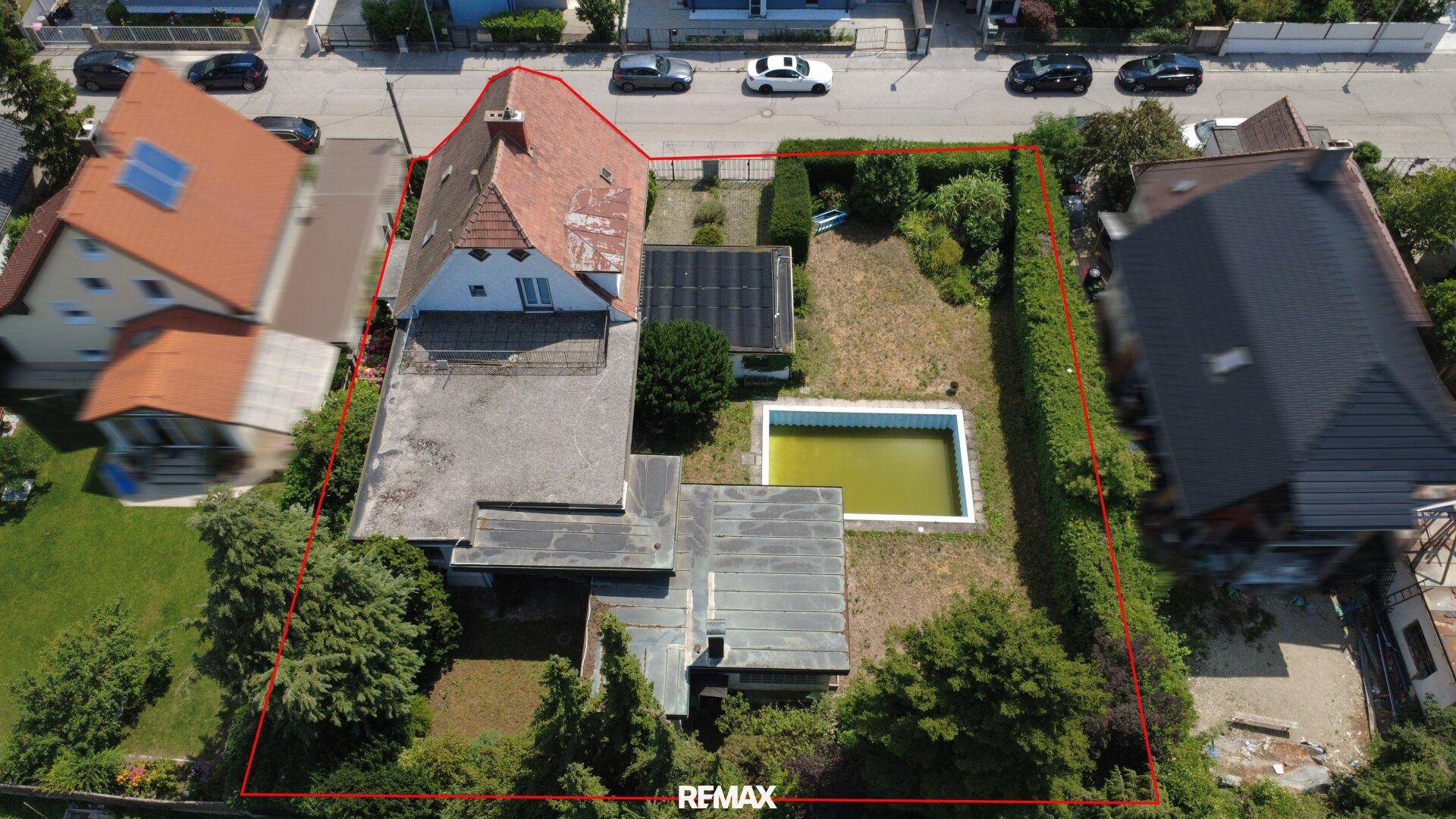 Luftaufnahme des Grundstücks mit markierten Grenzen, Haus, Pool und Garten.
