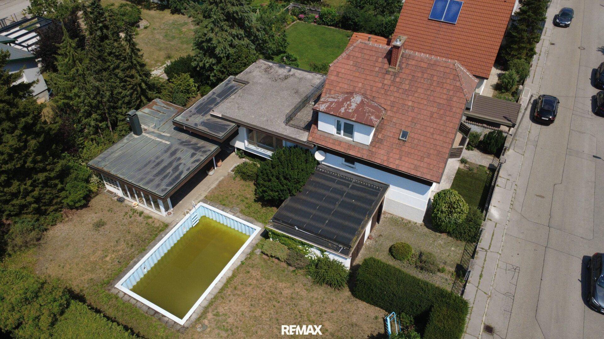 Luftaufnahme des Anwesens mit Hauptgebäude, Nebengebäuden, Pool und Garten.