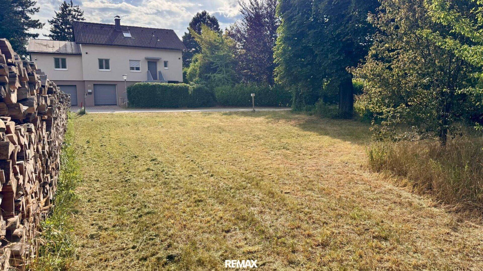Großes Grundstück mit Rasenfläche und Blick auf das Nachbarhaus.