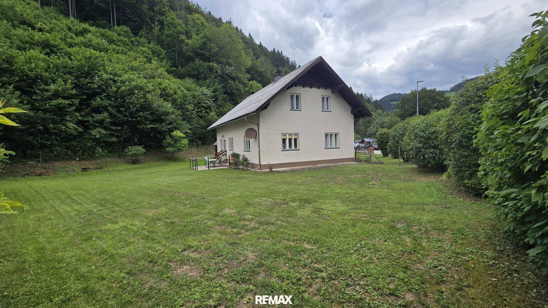 Freistehendes Haus mit großem Garten und grüner Umgebung am Waldrand.