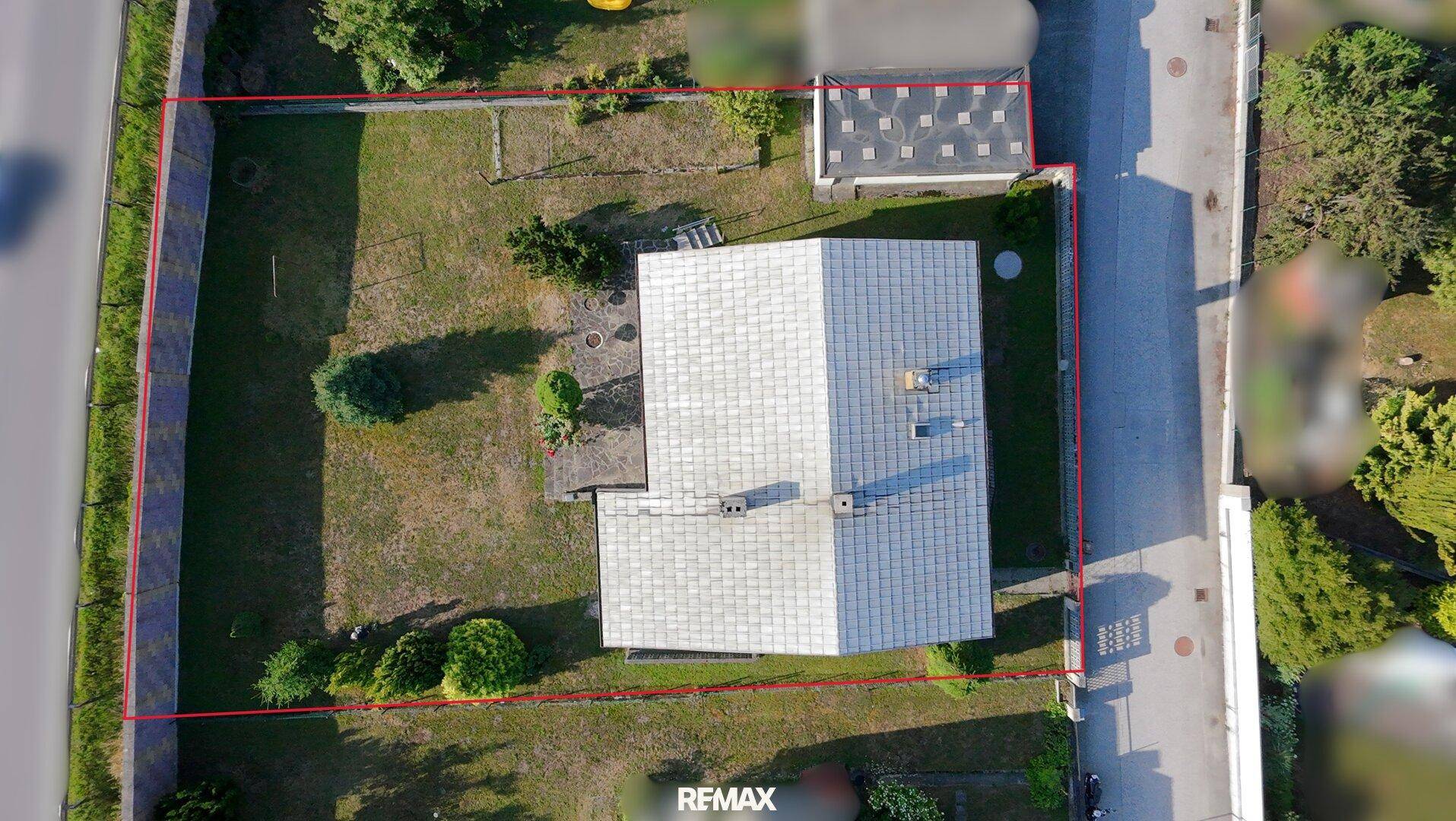 Draufsicht des Grundstücks mit roter Umrandung, zeigt Haus, Garage und Garten.