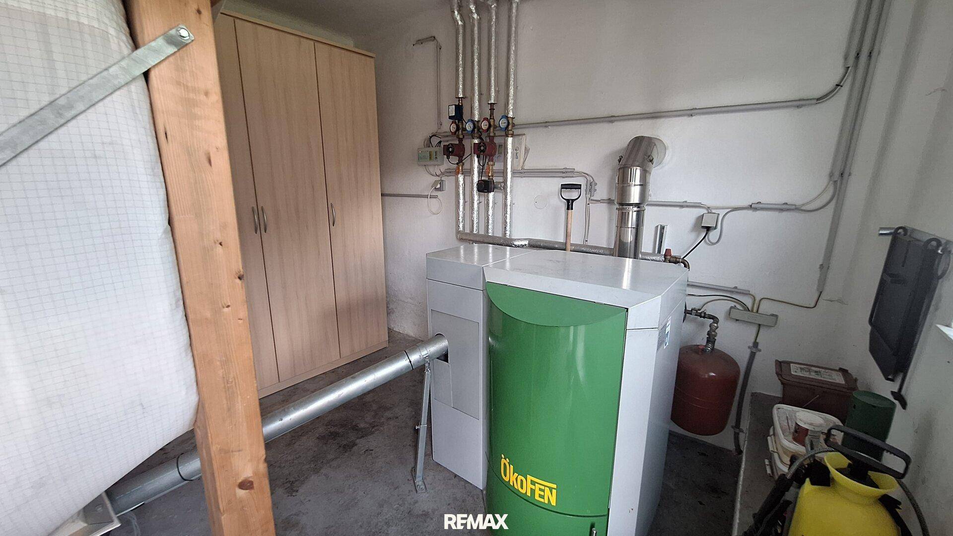Heizungsraum mit einem modernen Pelletkessel und sichtbaren Rohrleitungen.