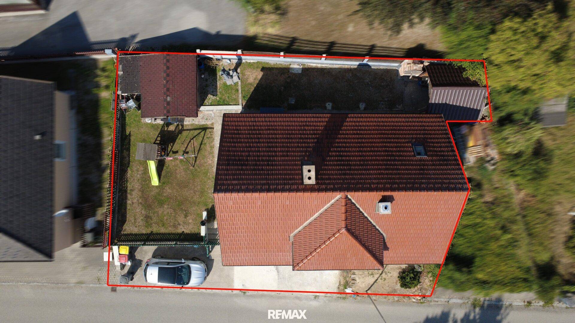 Übersichtsaufnahme des Grundstücks mit eingezeichneten Grenzen, Haus, Garten und Stellplatz.
